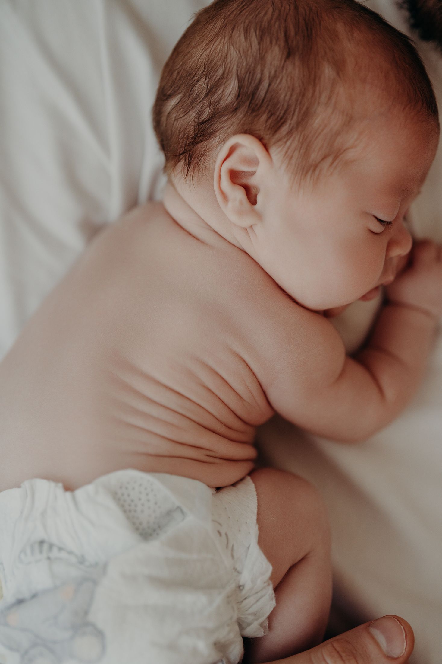Close-up of little baby features and soft baby rolls during natural lifestyle newborn photography in Dublin,