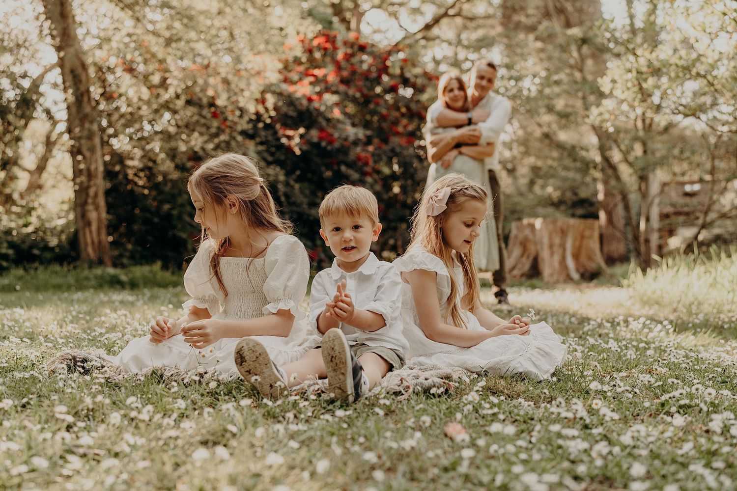 Family enjoying a sunny day together in a blooming spring meadow.