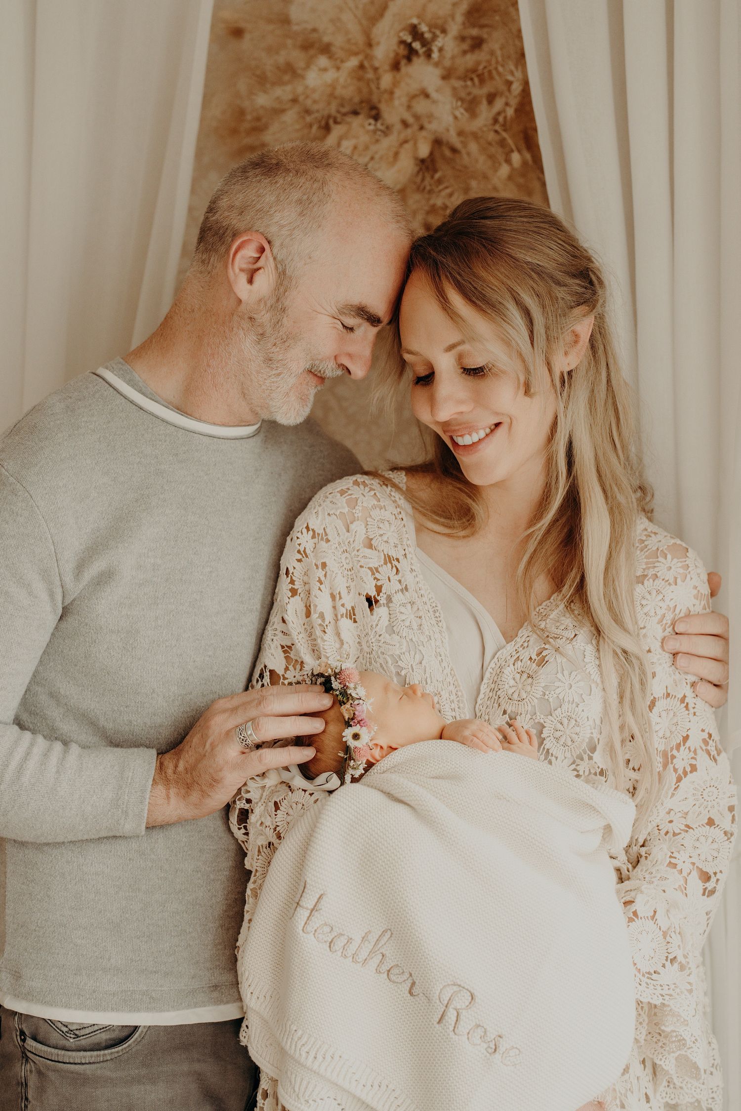 Intimate family portrait session with newborn in soft natural window light.