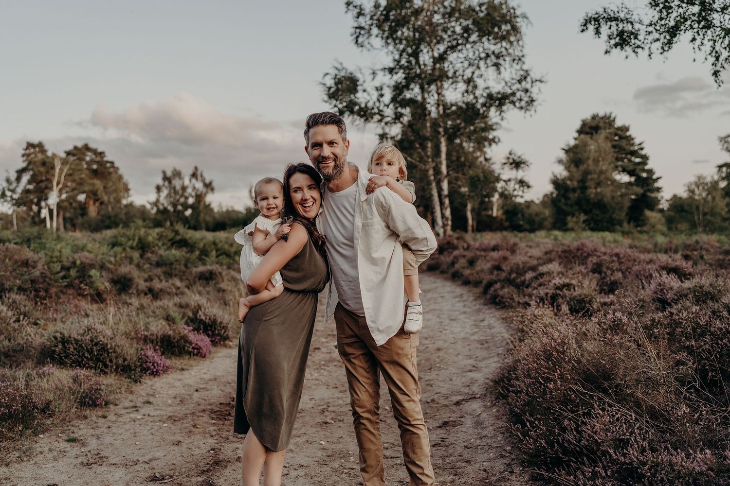 Family walking together through a scenic natural landscape at sunset.