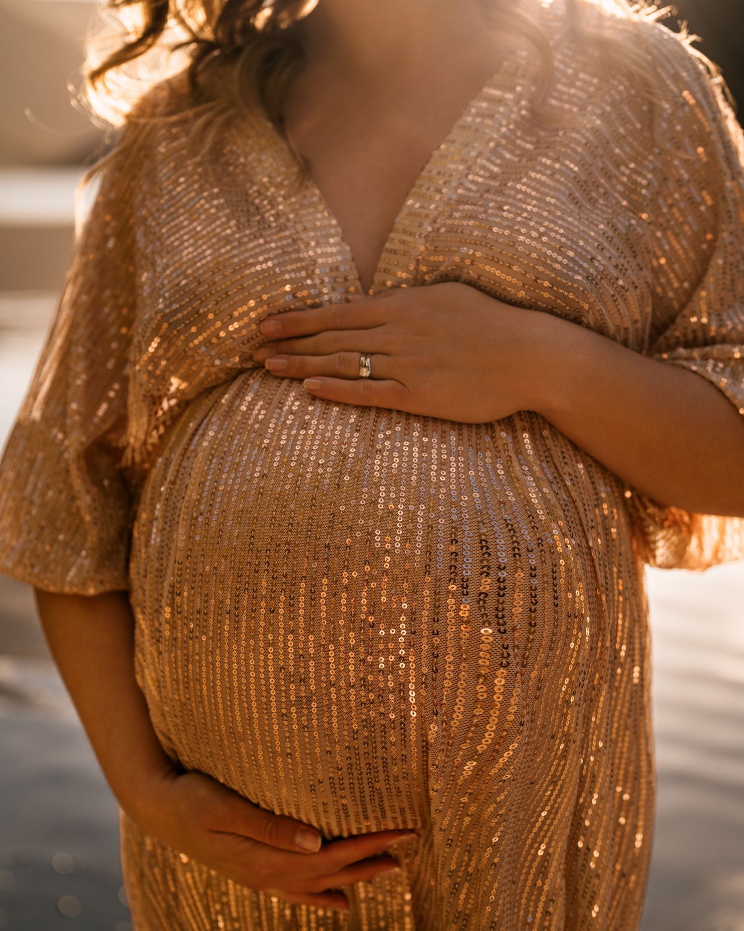 Close-up shots of a sparkly gold maternity dress showing the baby bump.