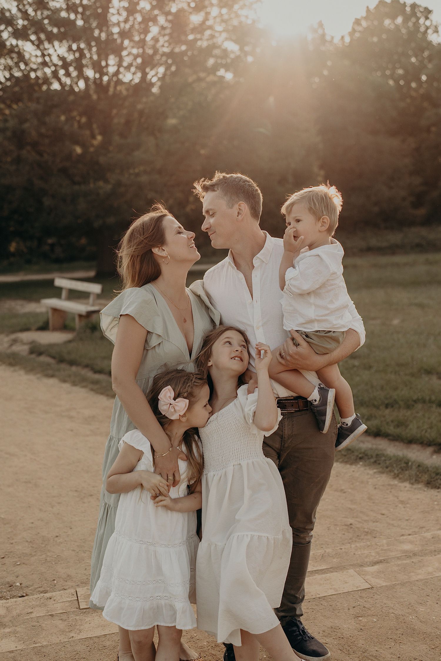 Family sharing intimate moments at sunset on a dirt path in casual spring attire.
