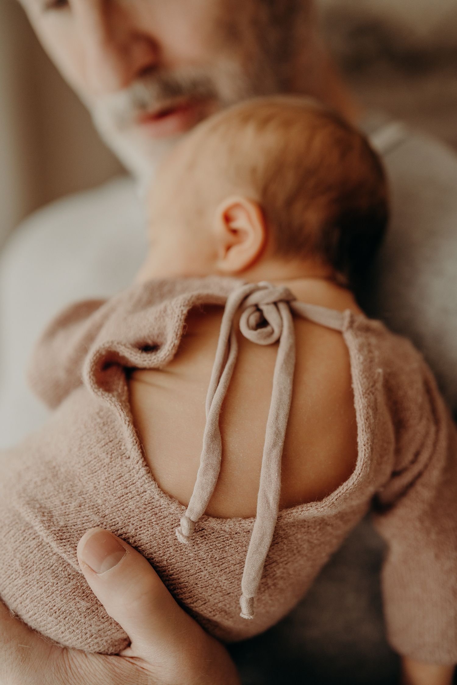 Close-up details of baby clothing and textures in muted tones.