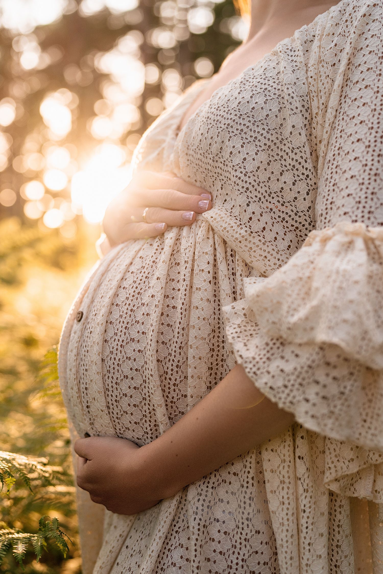 Detailed shots of a white lace maternity dress in golden sunlight.
