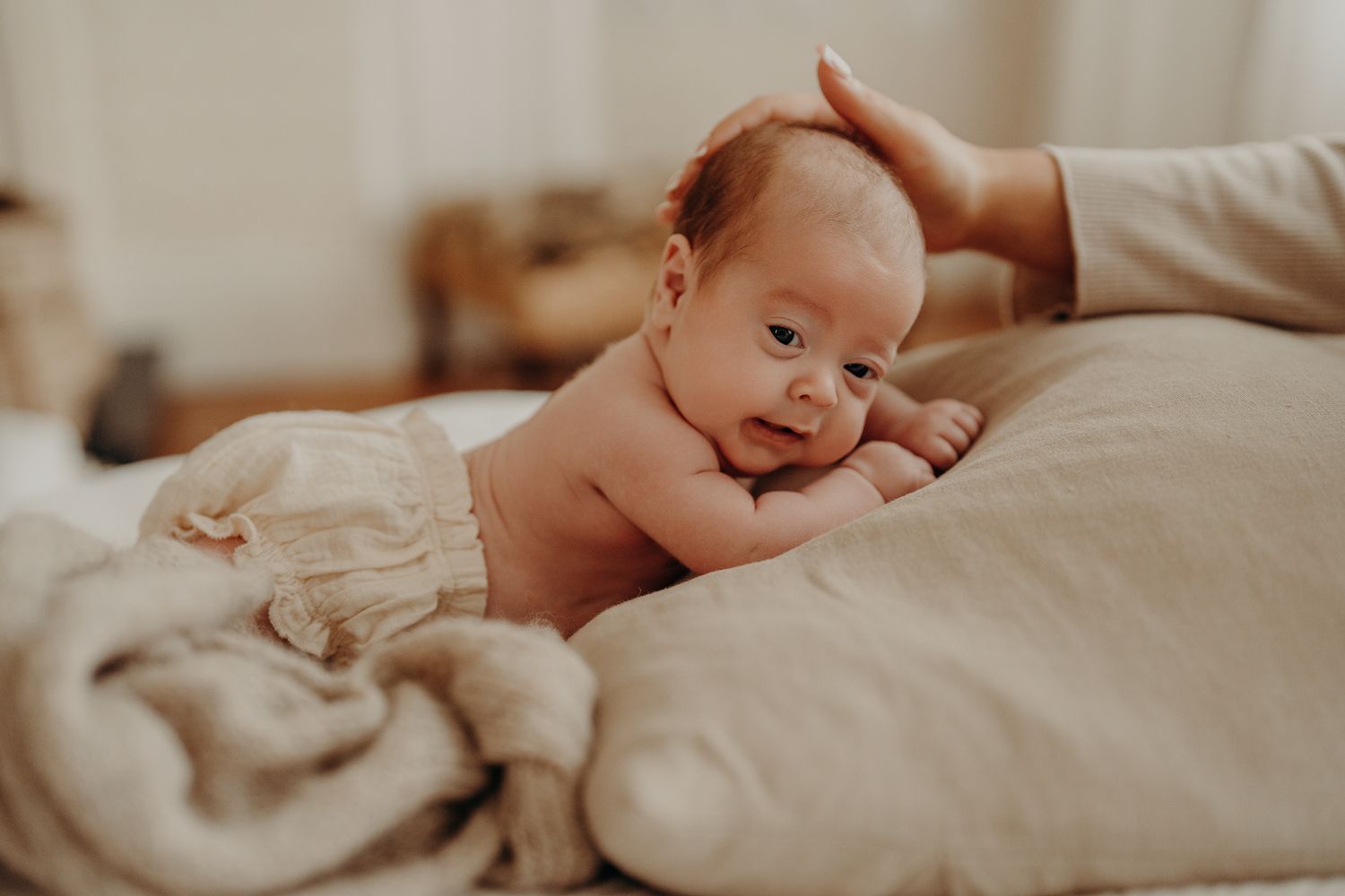Peaceful newborn baby with head up, looking in the camera, natural newborn session Dublin