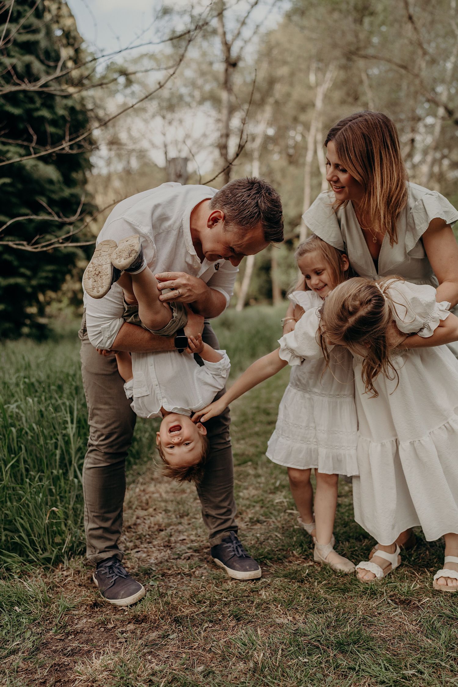 Sweet candid moments shared between family members in white dresses and casual wear outdoors.