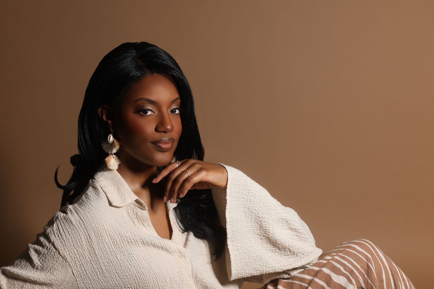 Cozy lifestyle portraits in cream sweater against warm brown background.