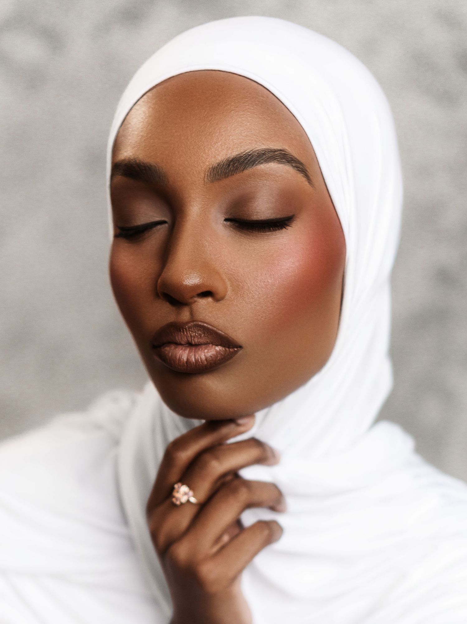 A beauty portrait series showing warm brown tones and white hijab against a light gray background.