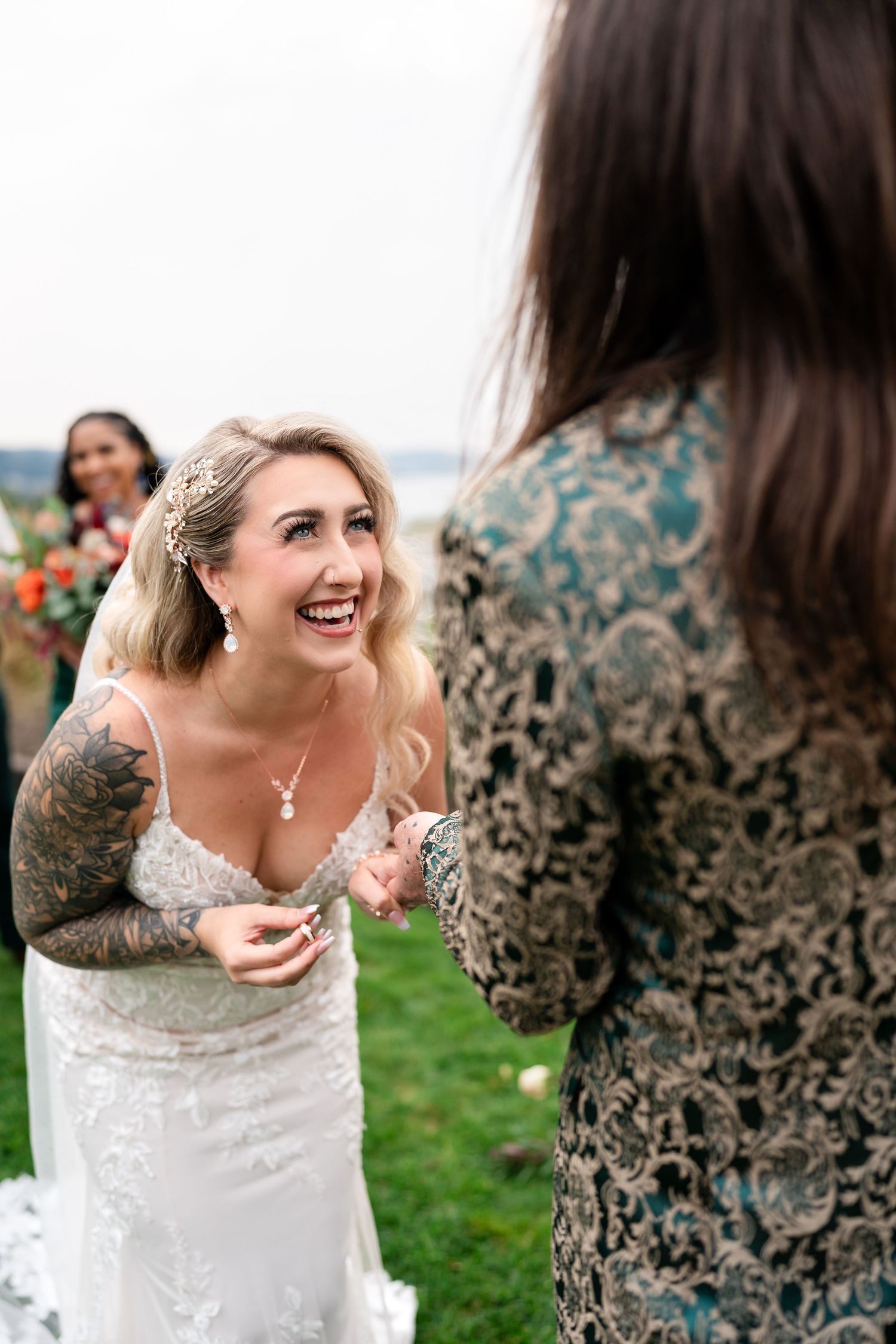 Candid moments of bride laughing with bridesmaids during outdoor wedding.