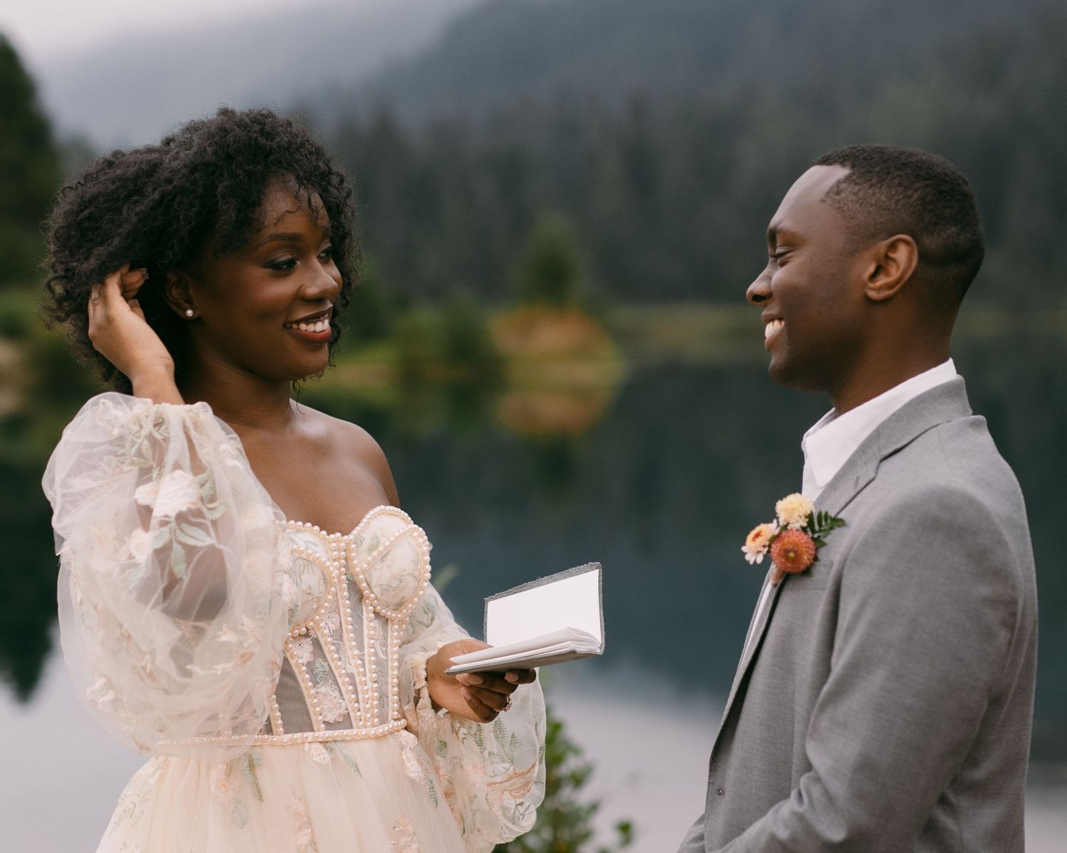 A couple shares romantic moments against a mountainous backdrop during their wedding photoshoot.