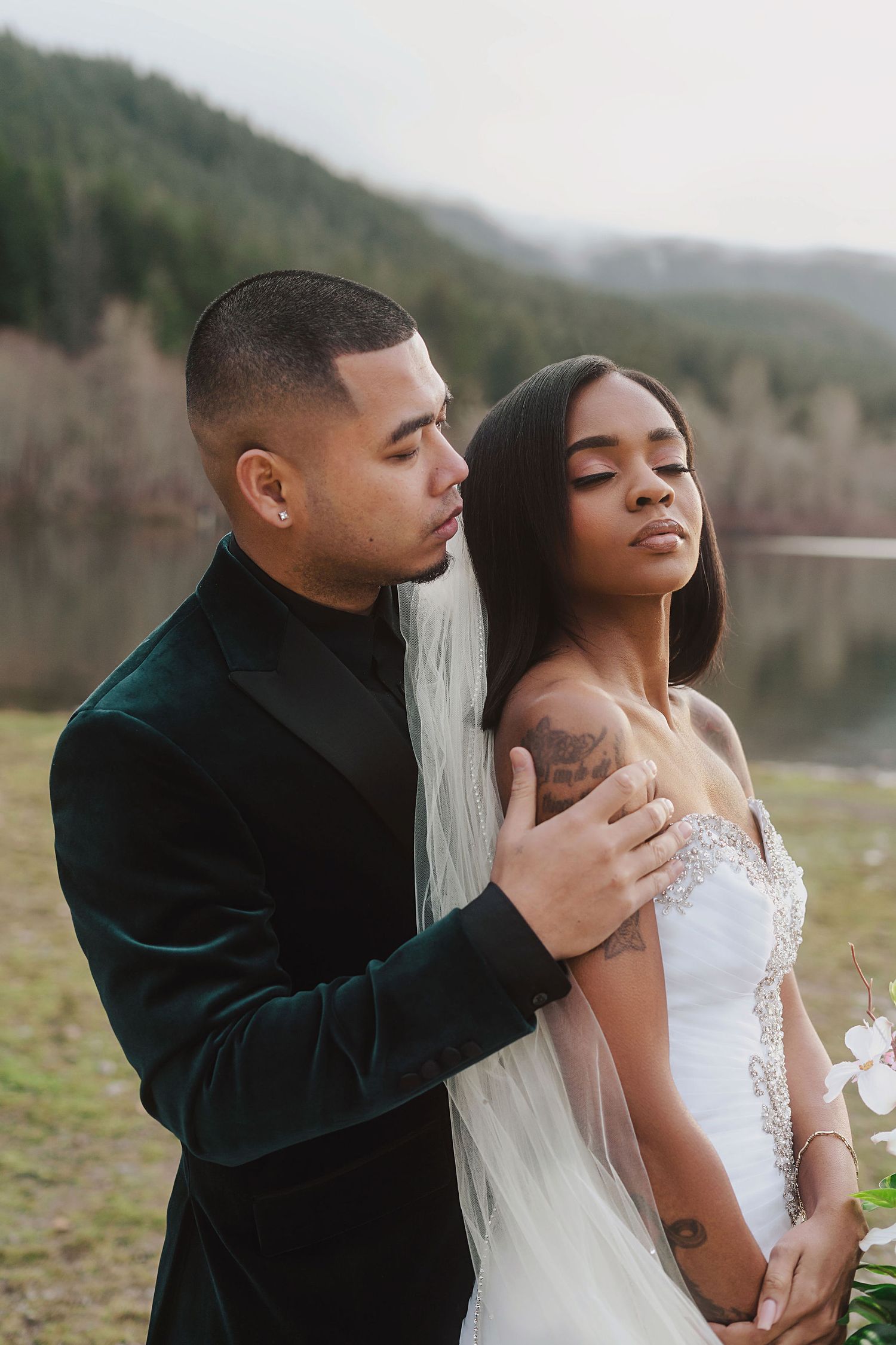 Intimate wedding portraits showing tender moments between a couple by a lake.