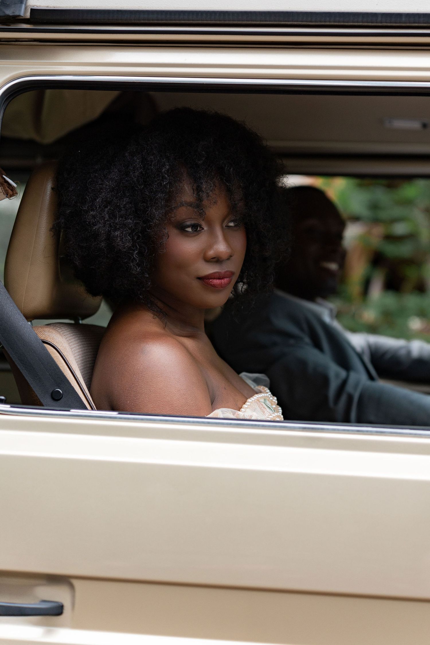 A romantic wedding photo series taken through the window of a classic cream-colored car.