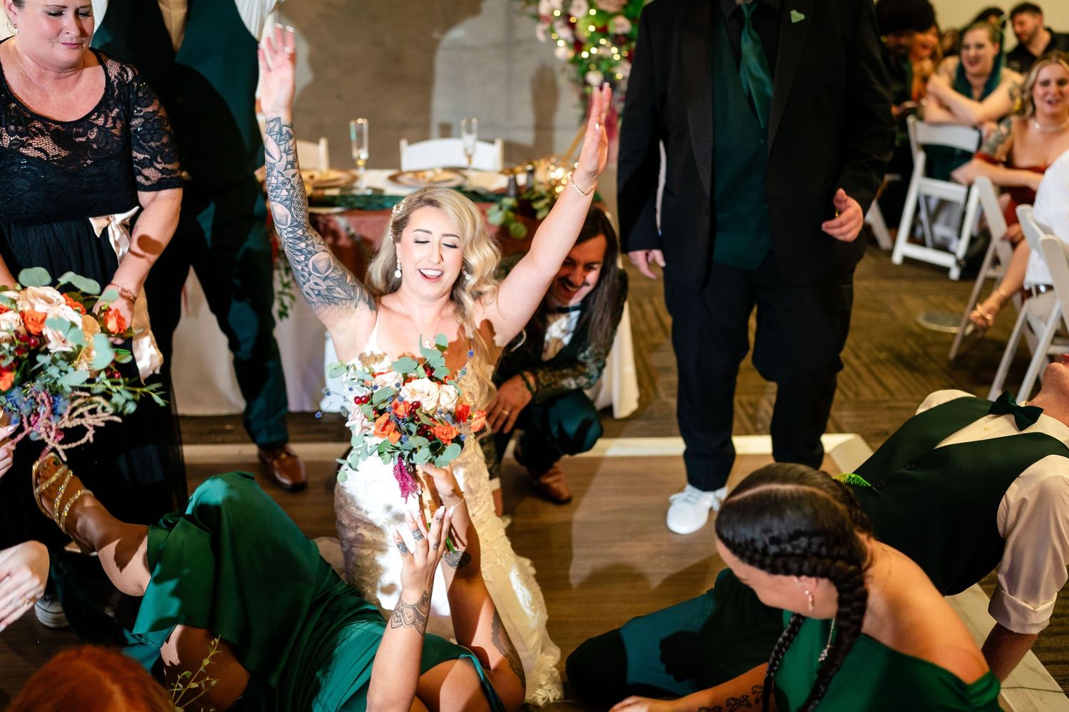 A joyful celebration moment during a wedding reception with guests dancing.
