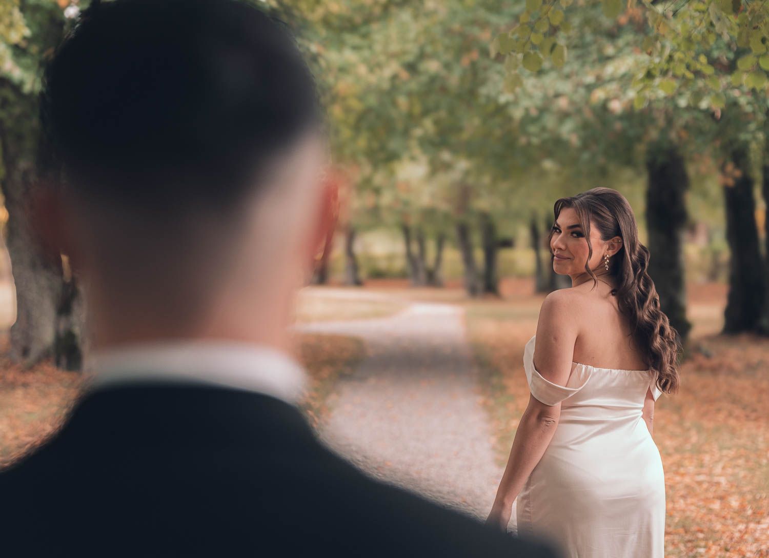 brud tittar bakåt mot sin man vid en förlovningsfotografering i slottsmiljö utanför Västerås