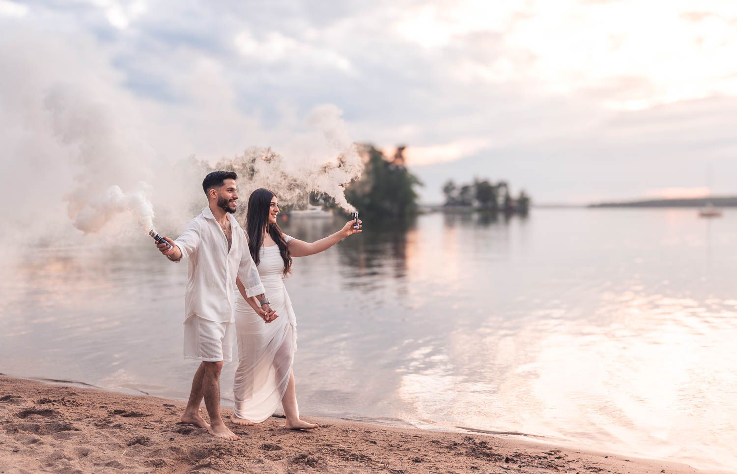 Par går på stranden efter att mannen har friat och håller i en varsin rökpatron
