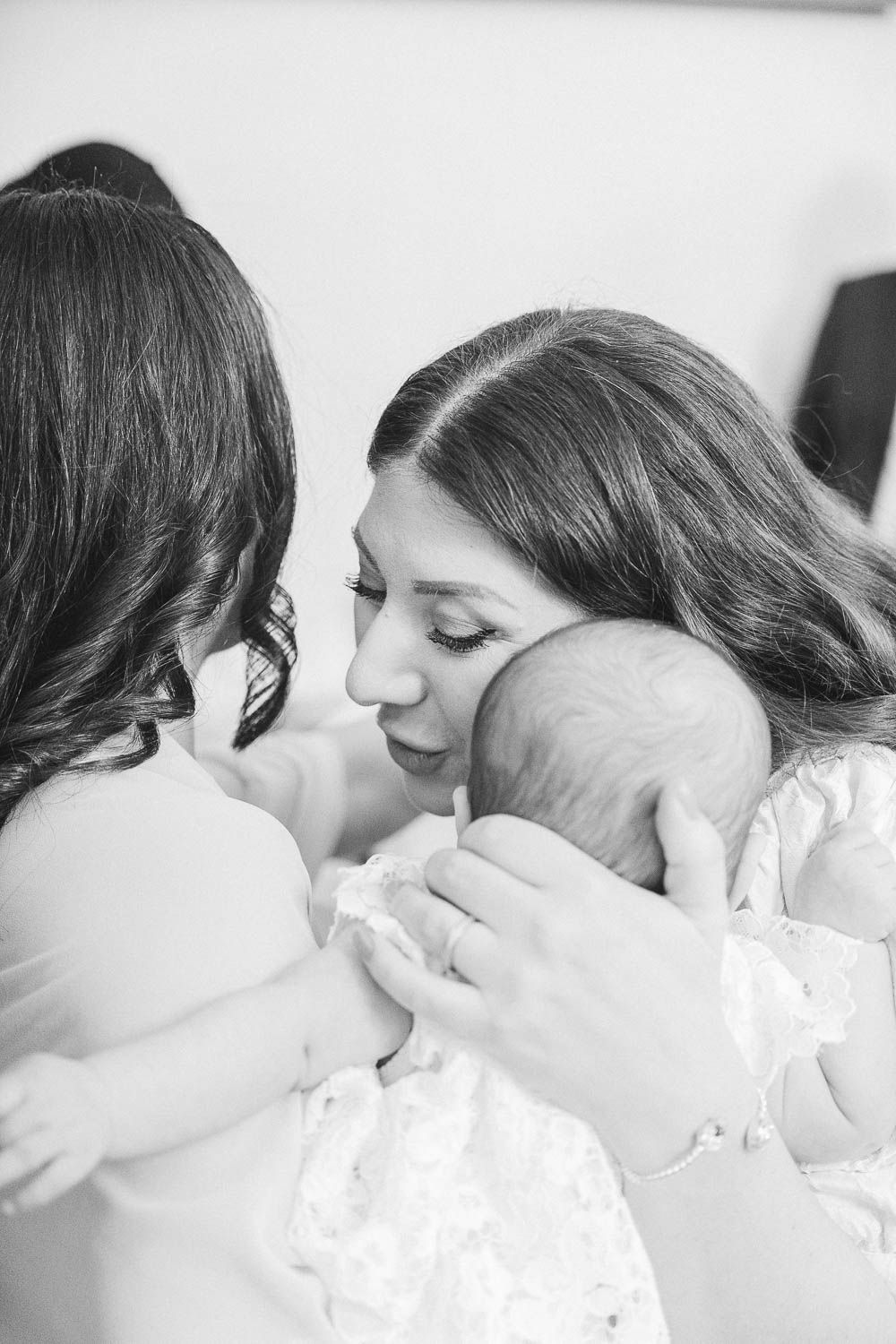 Mamma håller sitt barn efter dopceremonin – känslosamt ögonblick vid dopfotografering i Norrköping