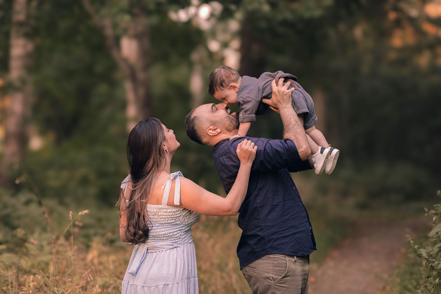 en glad familj under en somrig familjefotografering utanför eskilstuna