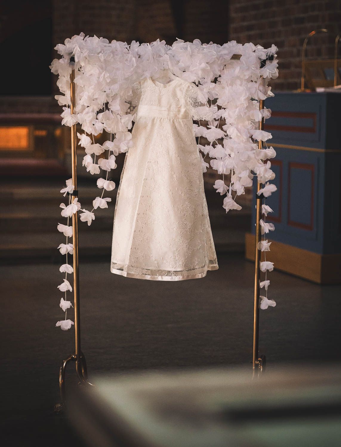 detaljbild av dopklänning som hänger innan en dopceremoni