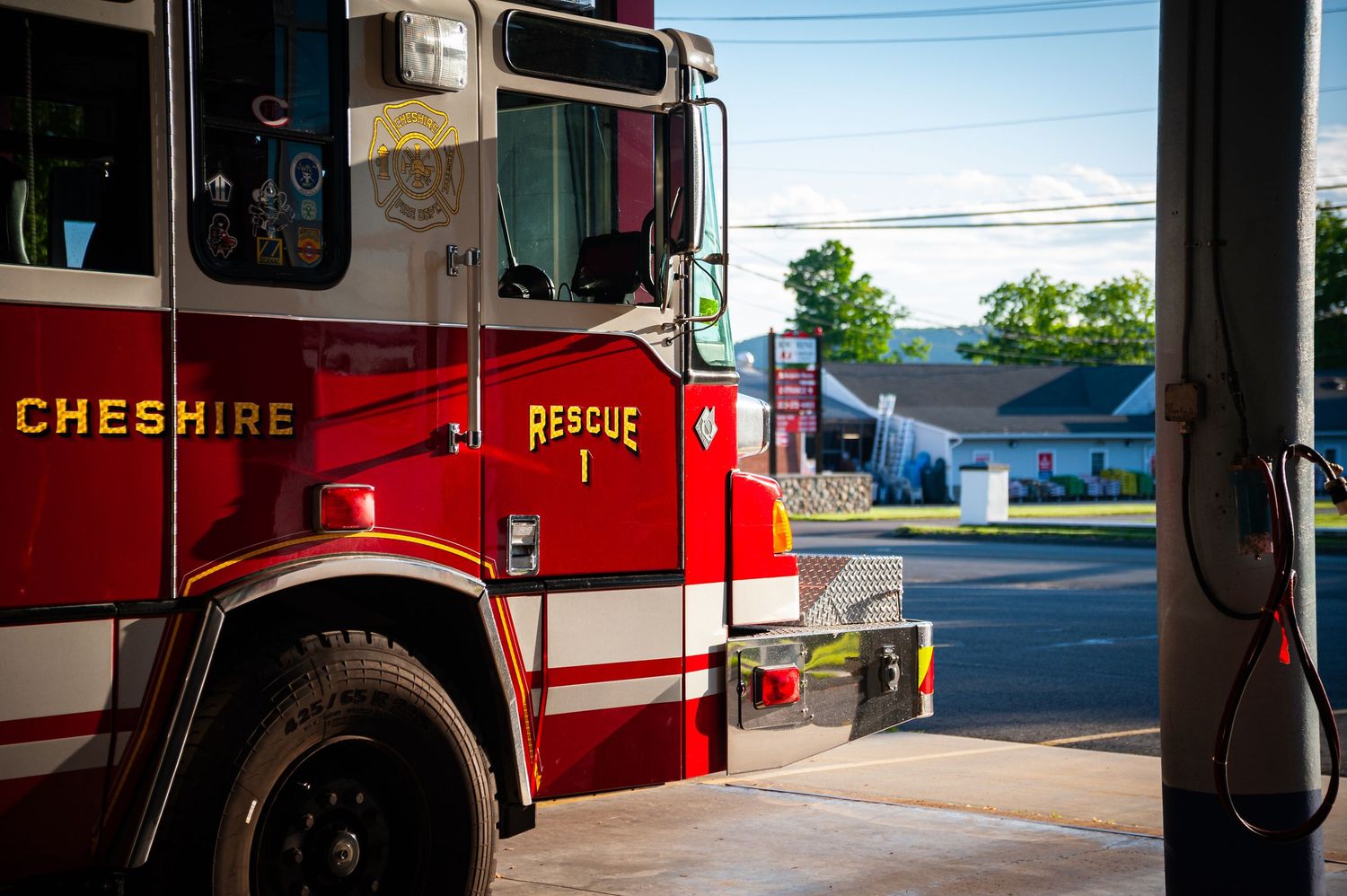 Cheshire Fire Department Rescue 1 red fire truck parked at station bay on sunny day.