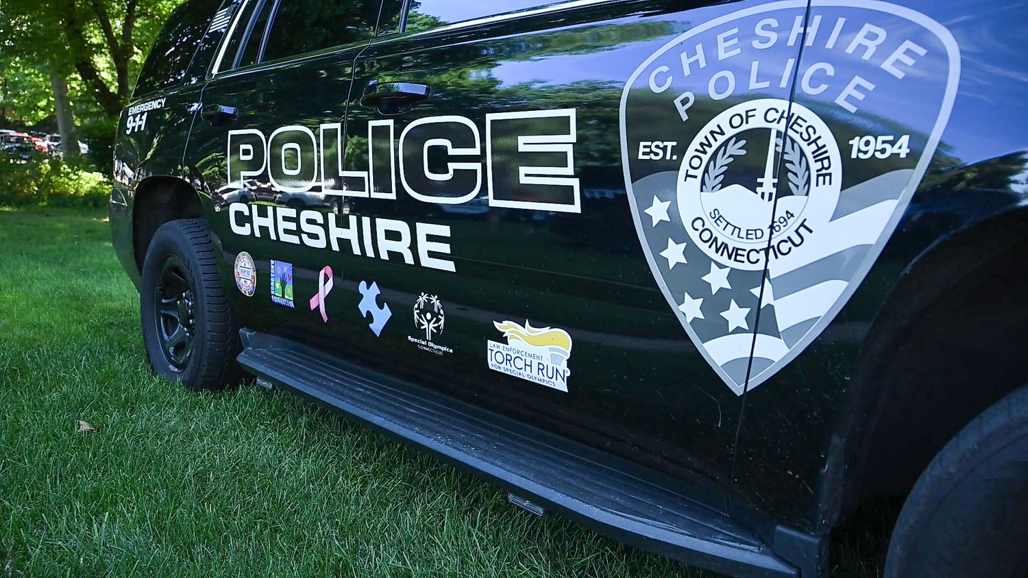 Cheshire Police Department patrol vehicle with official town seal, established 1954, parked on grass in Connecticut.