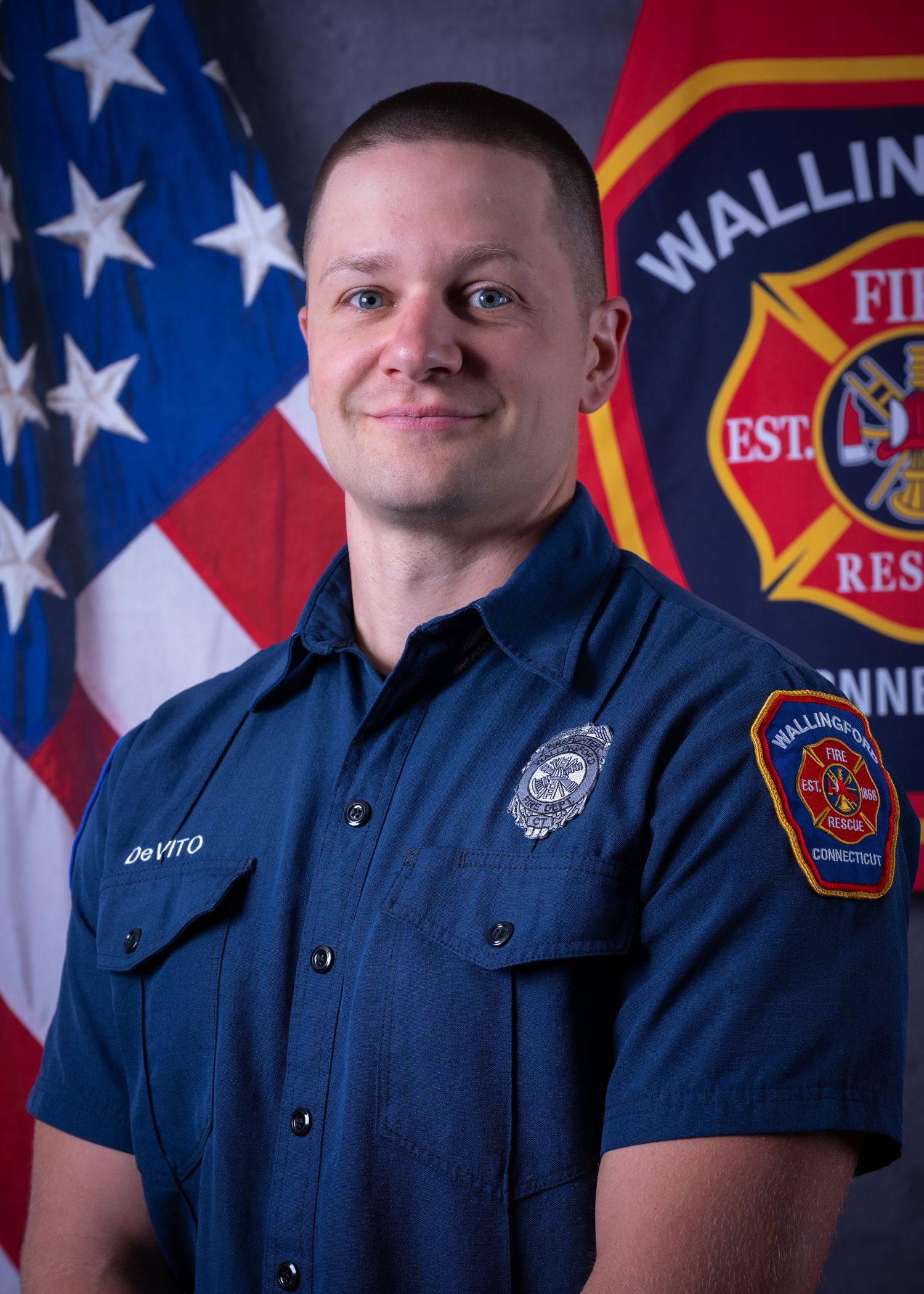 Wallingford Connecticut firefighter DeVito in navy uniform before American flag.