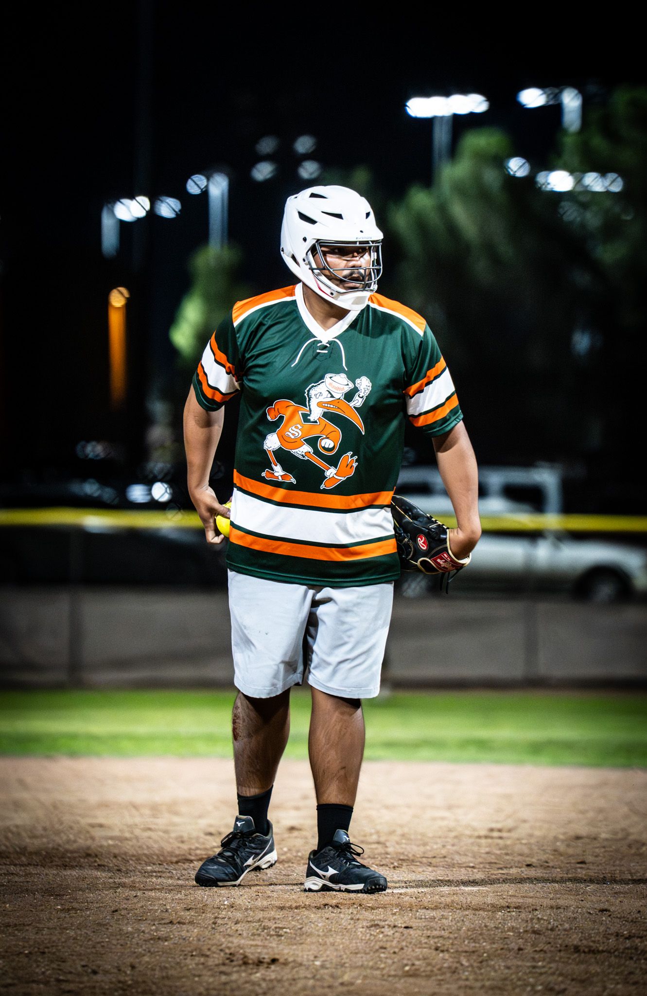 A sequence showing a softball player in a green and orange uniform crouching on the field in different positions.