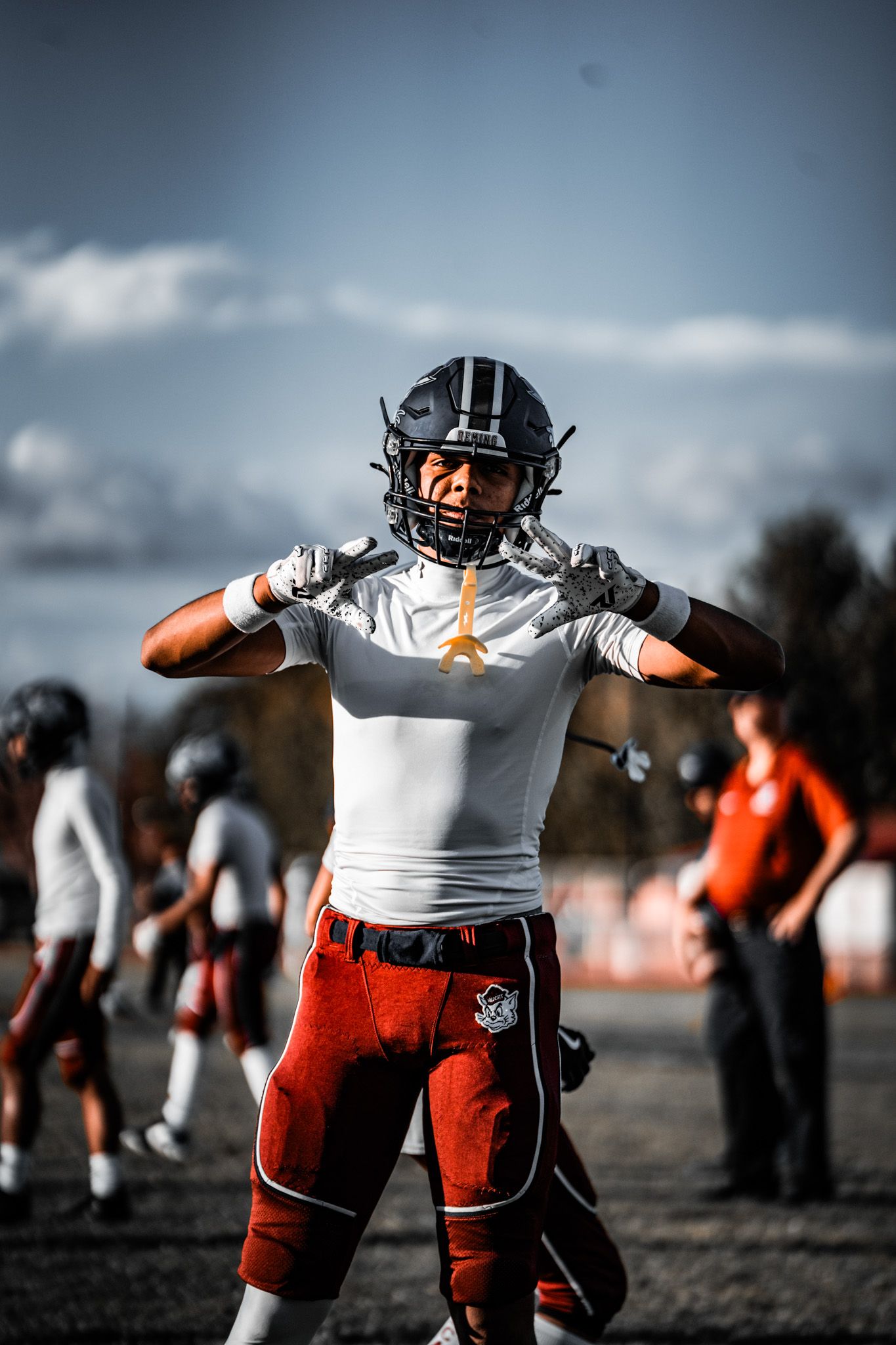 Football players in red and white uniforms stretch and warm up on a practice field during training.