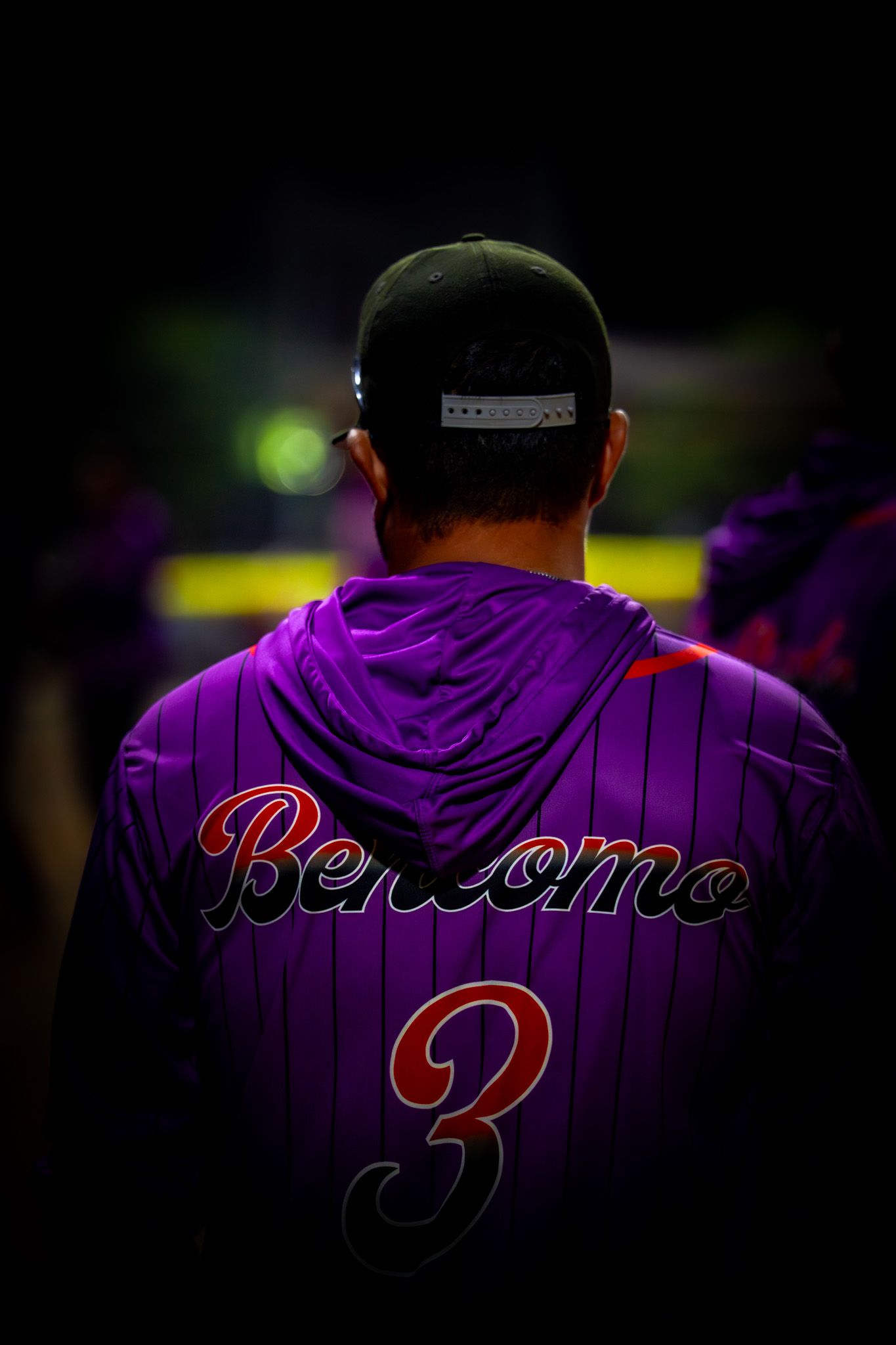 Baseball players wearing purple striped jerseys with 'Bejeweled' text stand in a dark stadium setting.