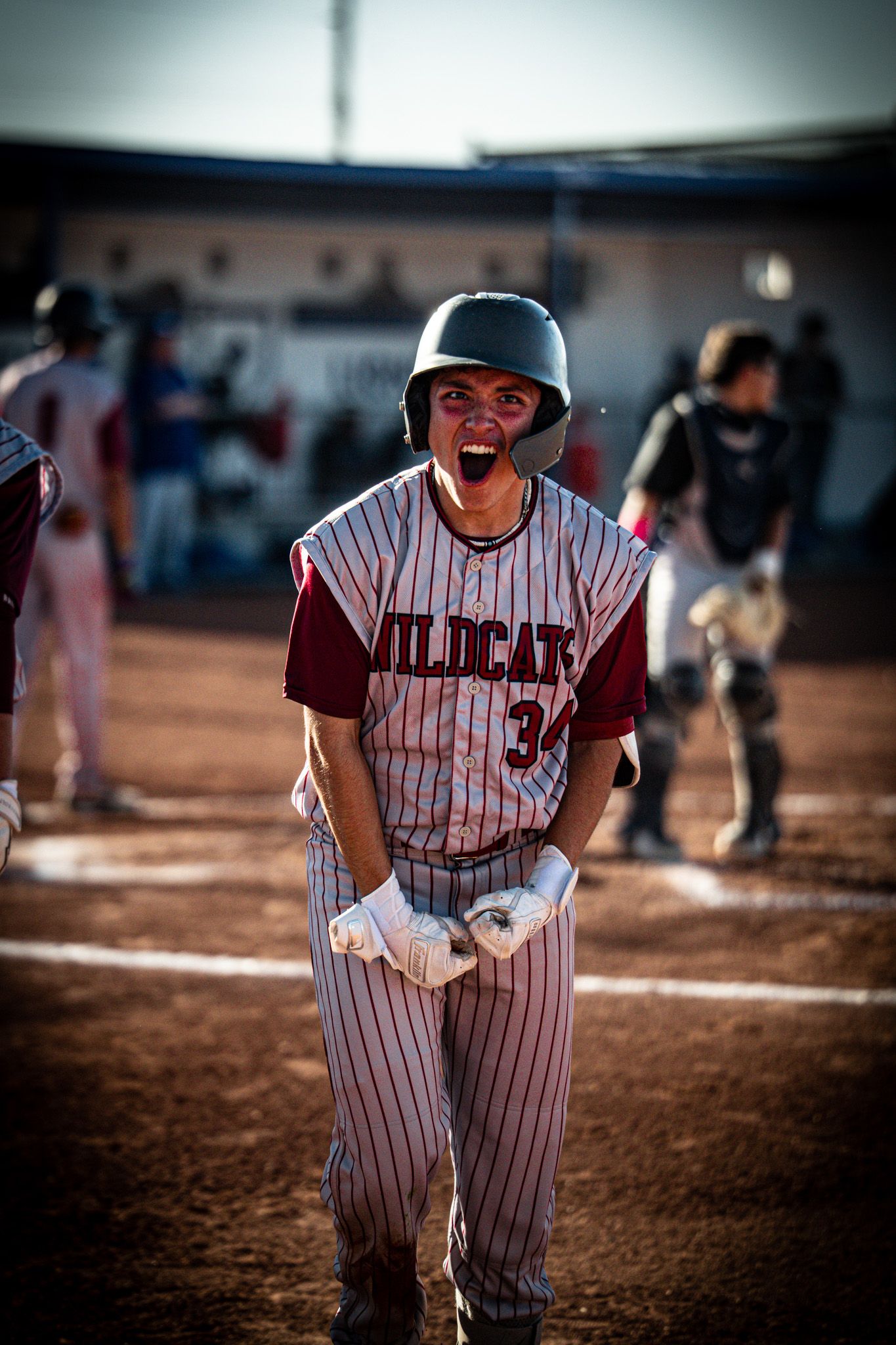 Baseball players in pinstriped uniforms showing intense emotion during game on dirt field.