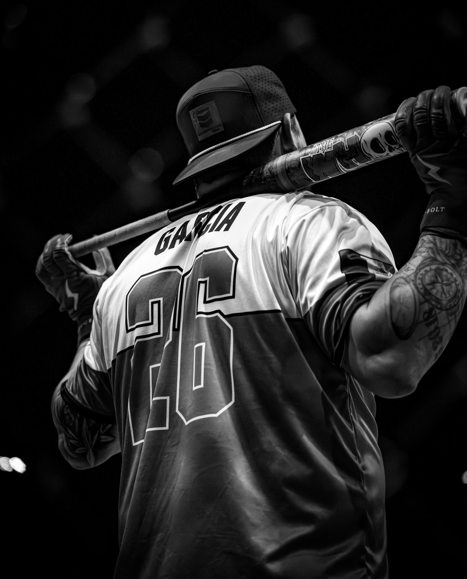 Black and white image shows baseball players in numbered jerseys lined up in a row during a game.