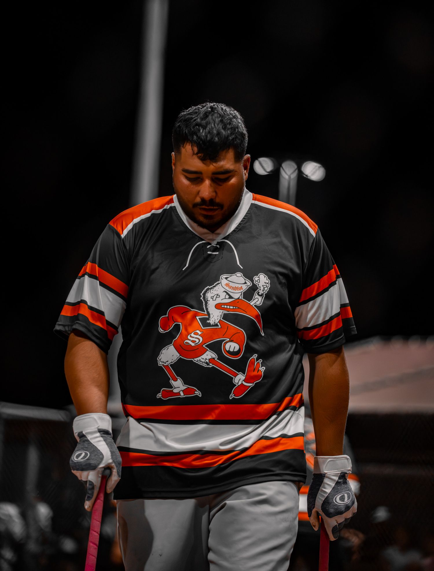 Rugby player in black and orange uniform shown from the torso down during a match.
