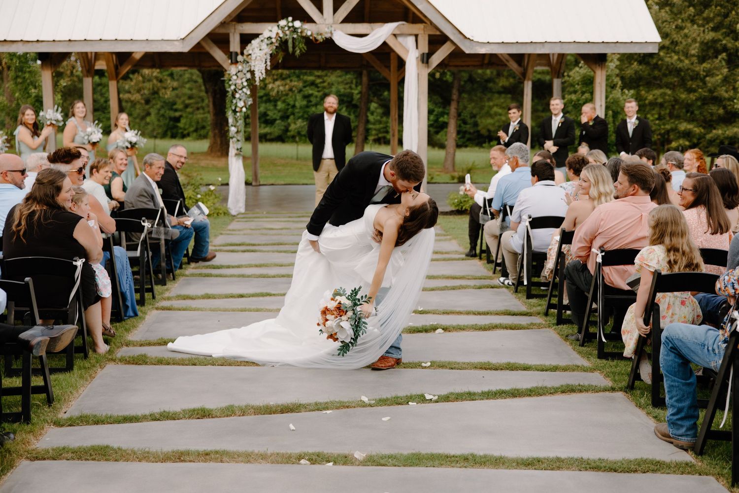 Newly married couple doing the iconic dip halfway down the aisle after saying 