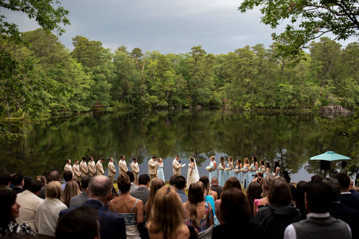 Wide photo of wedding ceremony at Camp Matollionequay in Medford, New Jersey from guests' perspective.