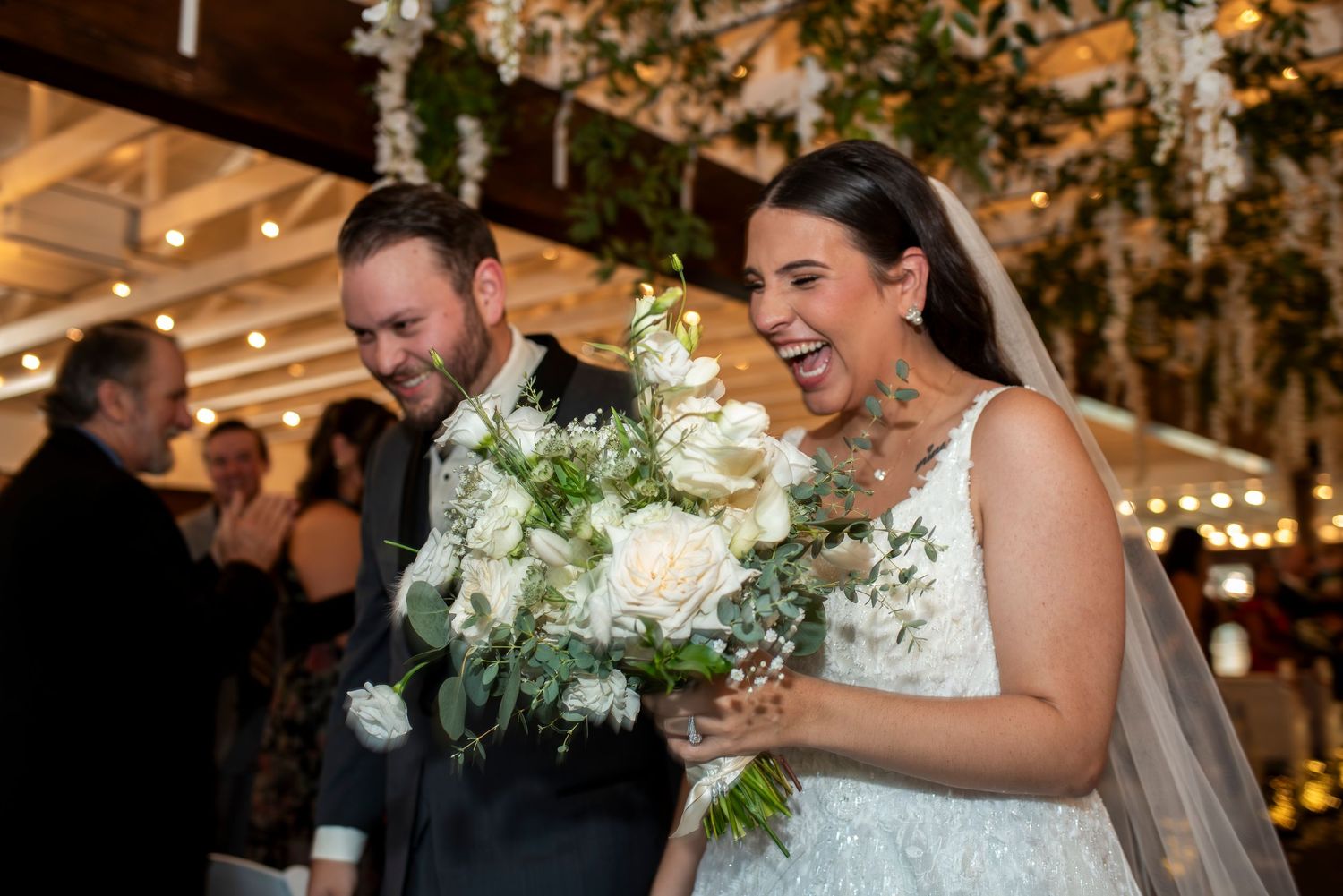 Bride and groom exit with big smiles after their wedding ceremony in the barn at Hamilton Manor, New Jersey.
