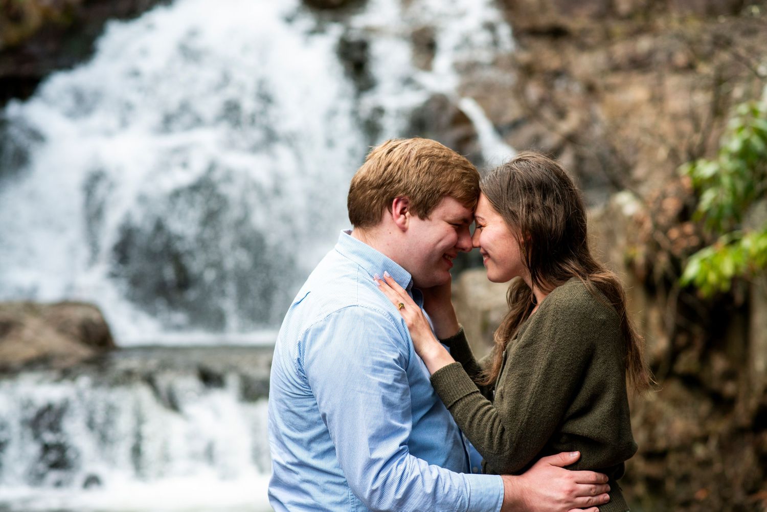 Couple smiles nose to nose in front of the waterfall in Hawk Falls, Pennsylvania.