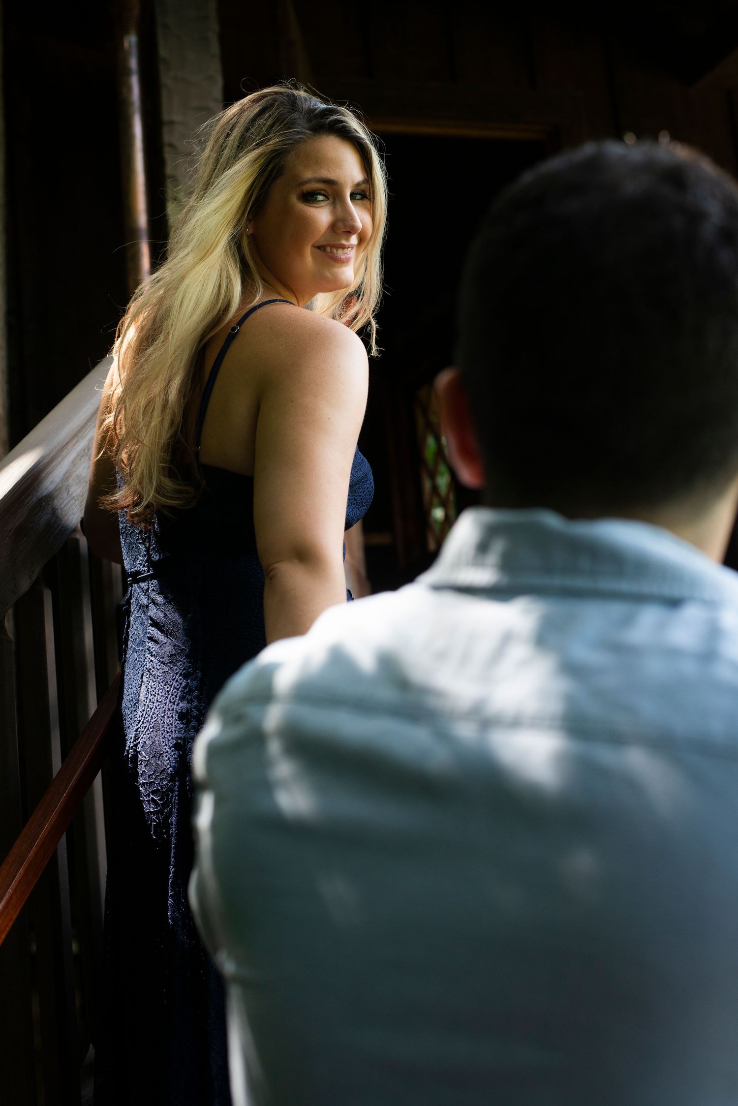 Bride looks back at her future husband as she ascends treehouse staircase during their engagement shoot at Longwood Gardens in Pennsylvania.