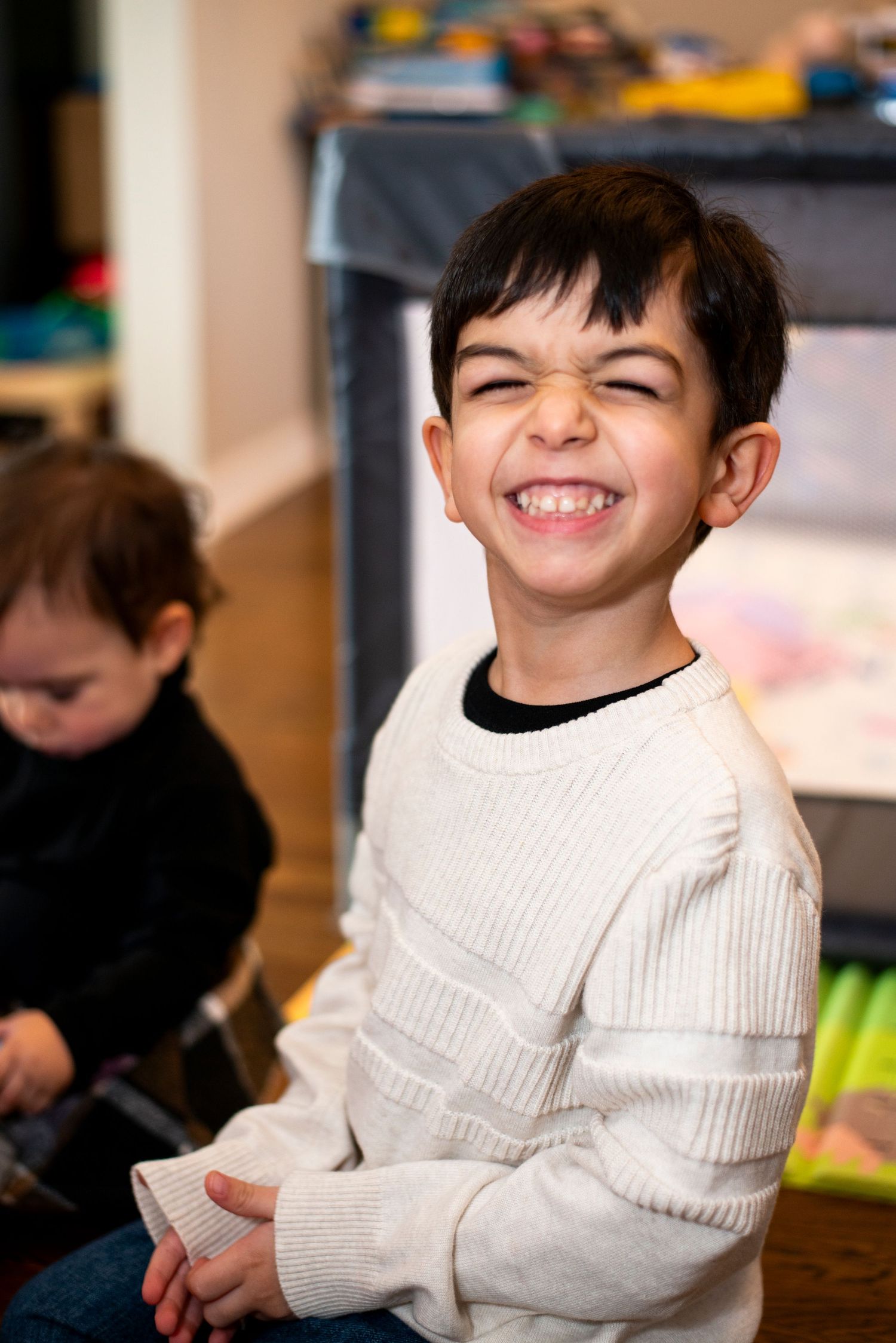 Young boy with big cheesy smile plays with toys in his home in Cherry Hill, NJ.