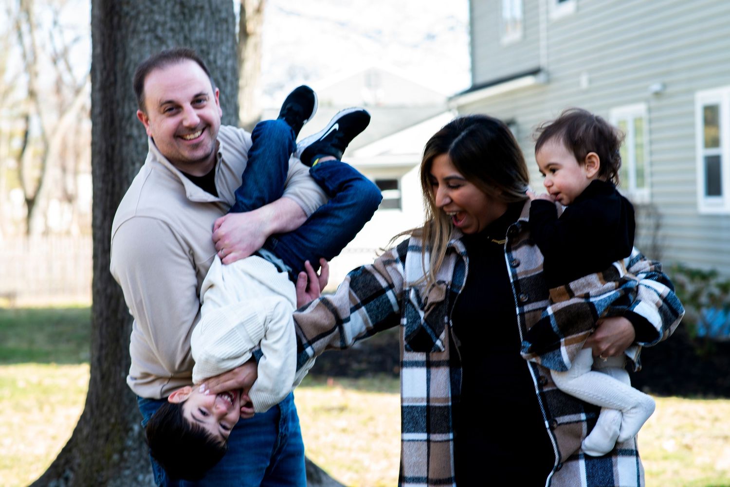 Family of four smiles and laughs, goofing around for their portrait at home in Cherry Hill, NJ.