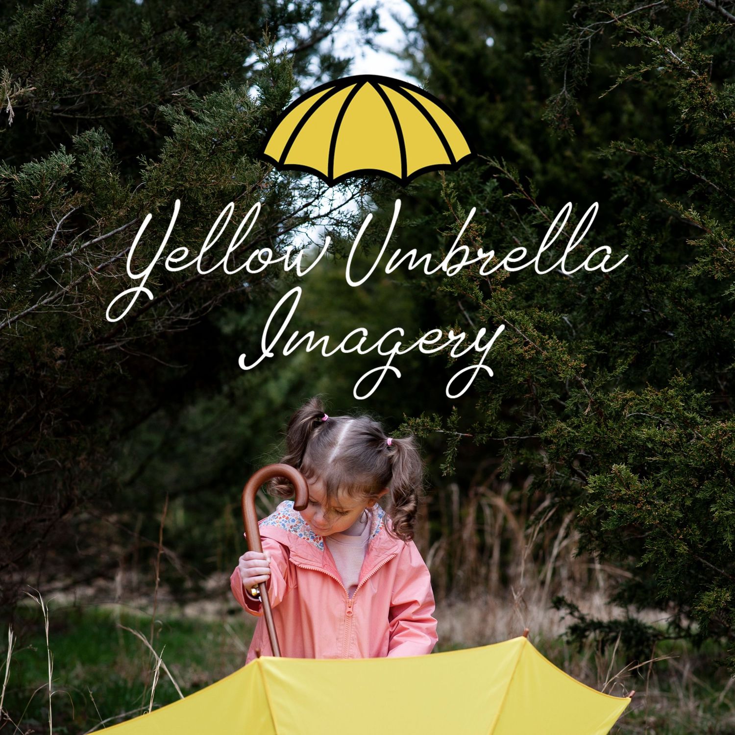 Young girl in pink raincoat plays with a yellow umbrella on a wooded path.