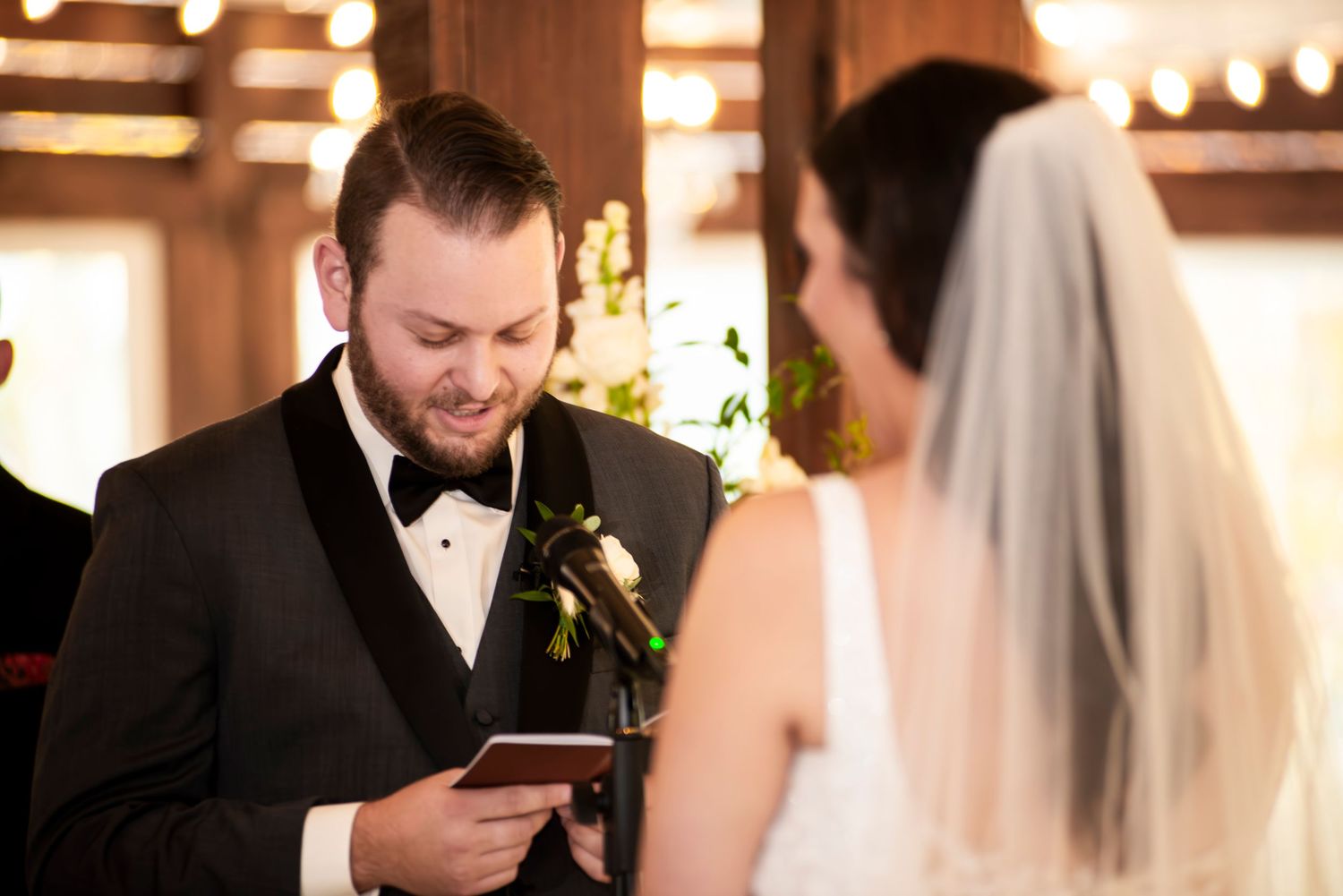 Groom reads his vows during wedding ceremony in the barn at Hamilton Manor, New Jersey.