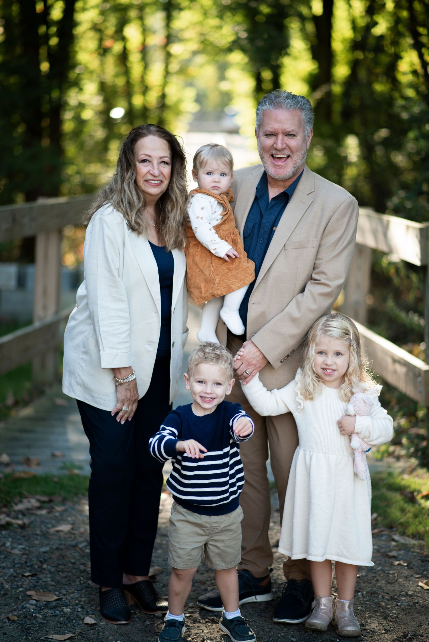 Portrait of grandparents smiling with their grandchildren in front of a bridge at Croft Farm in Cherry Hill, NJ.