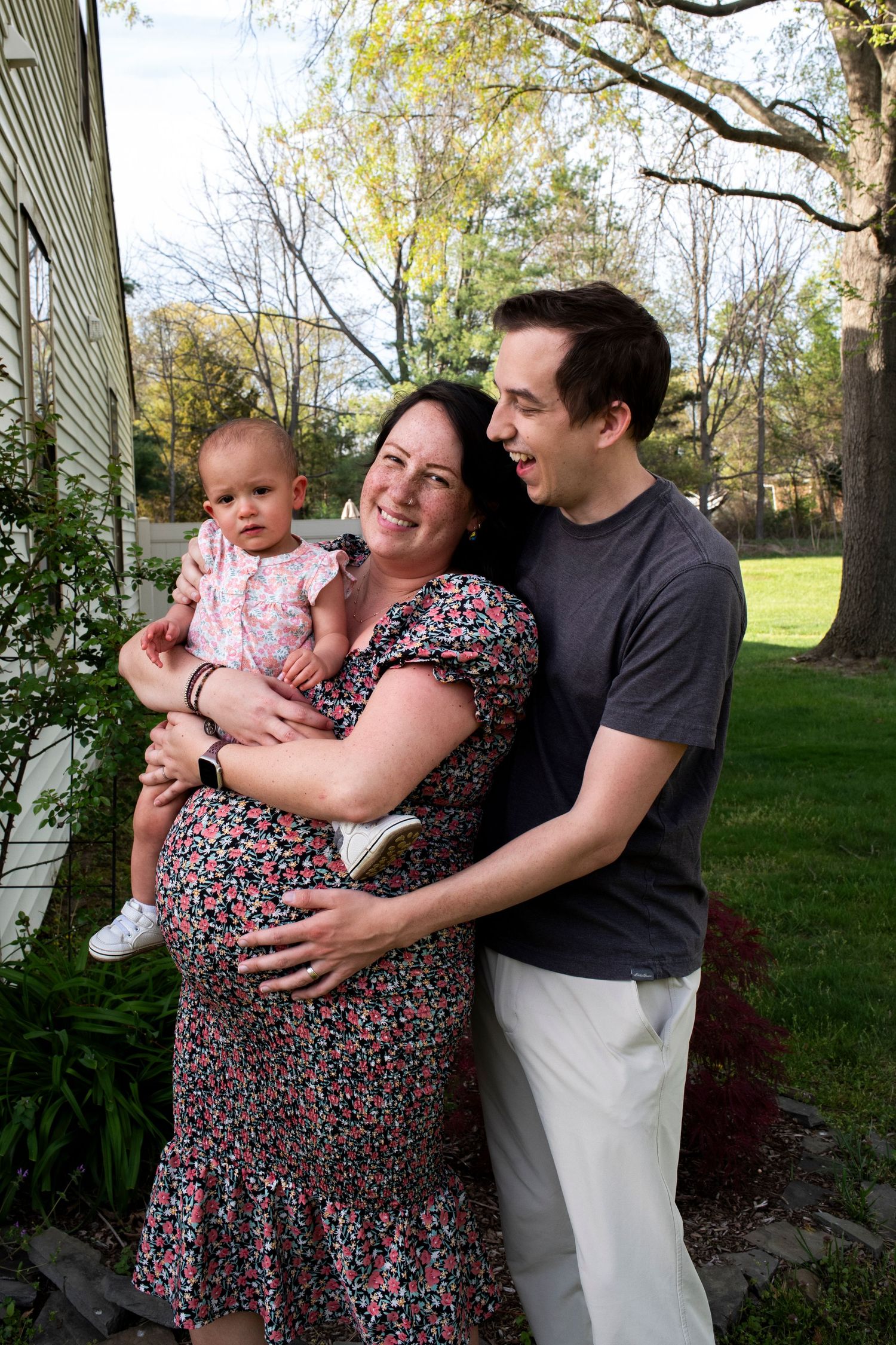 Family of three laughs at one another during maternity photoshoot in New Jersey.