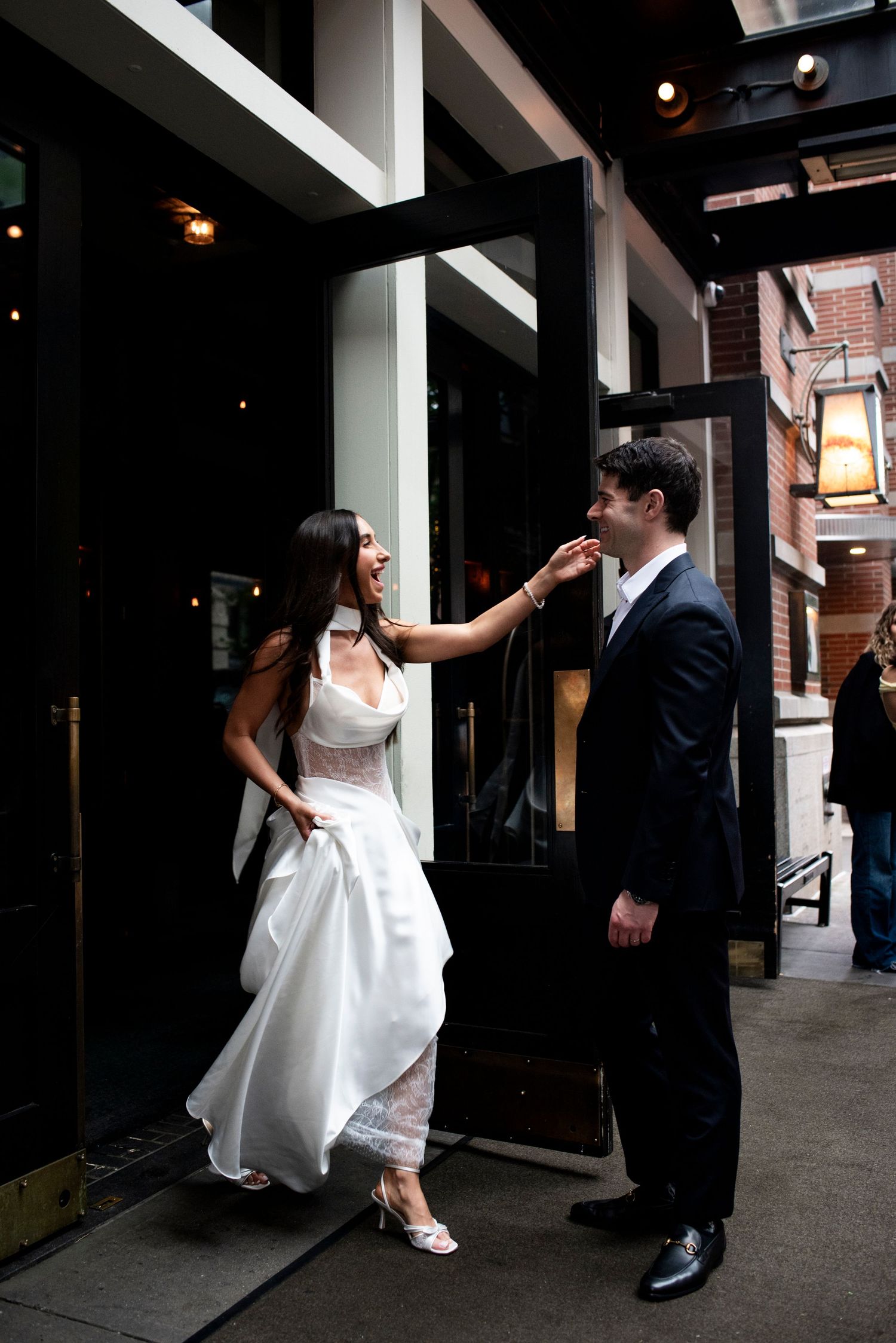 Bride greets groom with excitement as she exits the hotel in New York City.