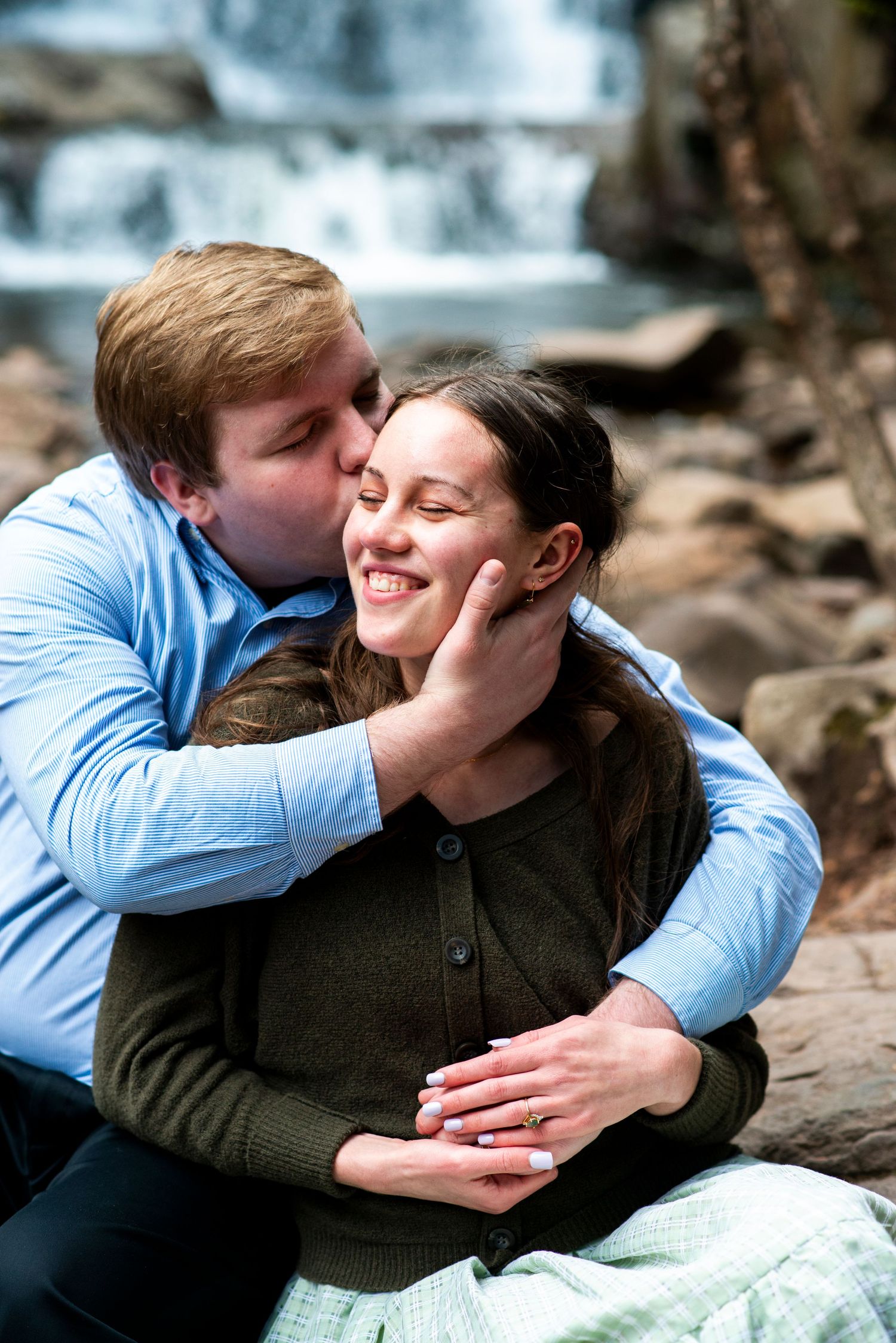 Groom pulls bride in for a kiss during their engagement shoot at Hawk Falls in Pennsylvania.