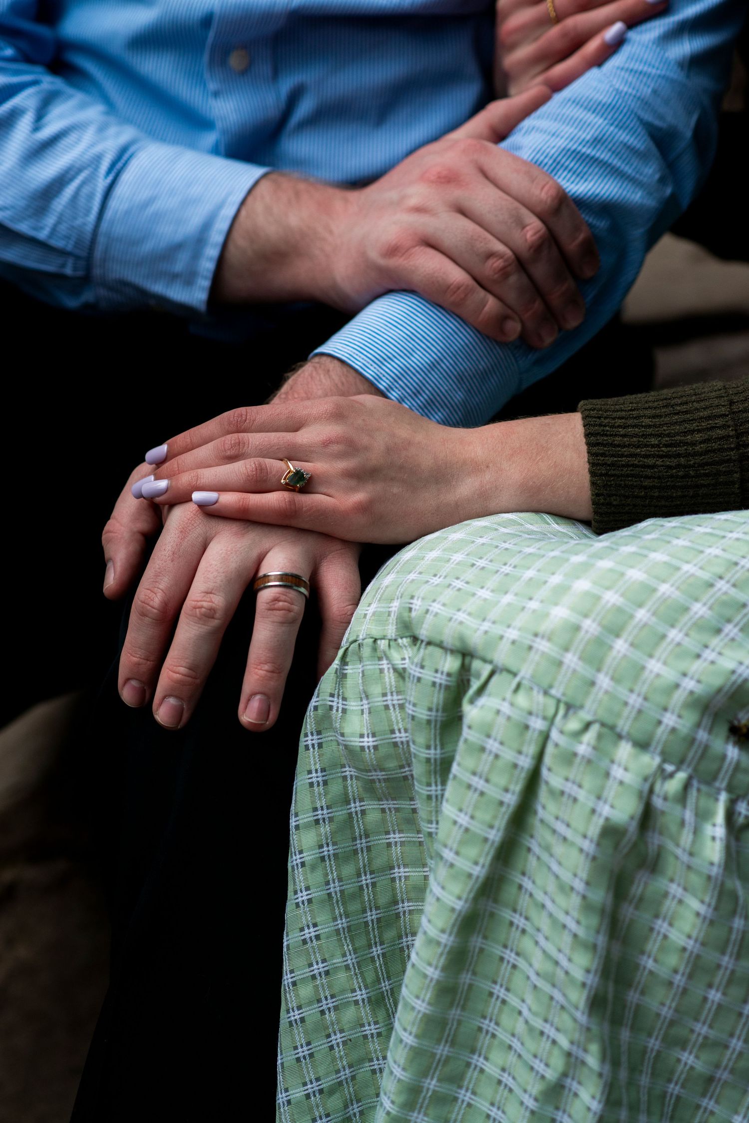Close up of couple's hands on their laps during engagement shoot at Hawk Falls in Pennsylvania.