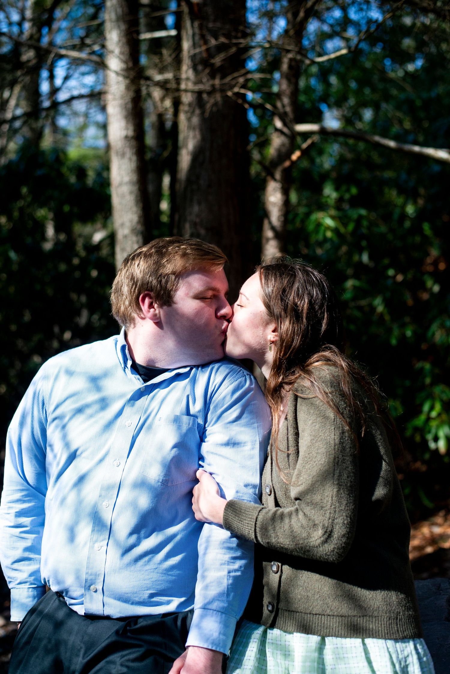Engaged couple go in for a kiss on the trail at Hawk Falls in Pennsylvania.