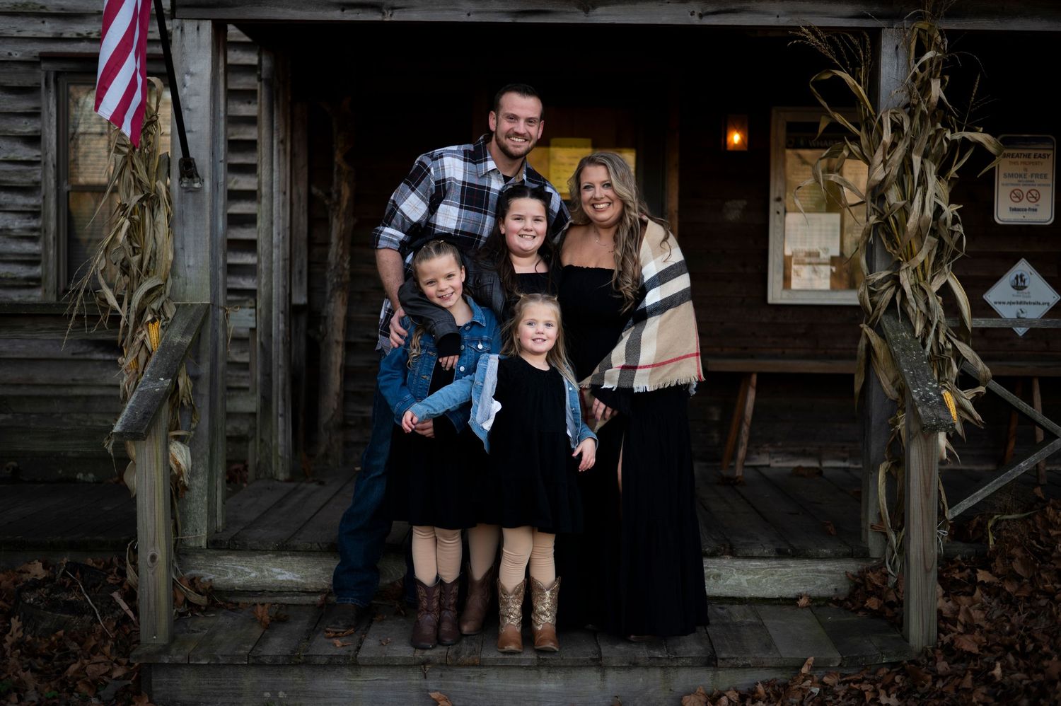 A family of five smiles for a portrait on the steps of of the nature building in Batsto Historic Village.