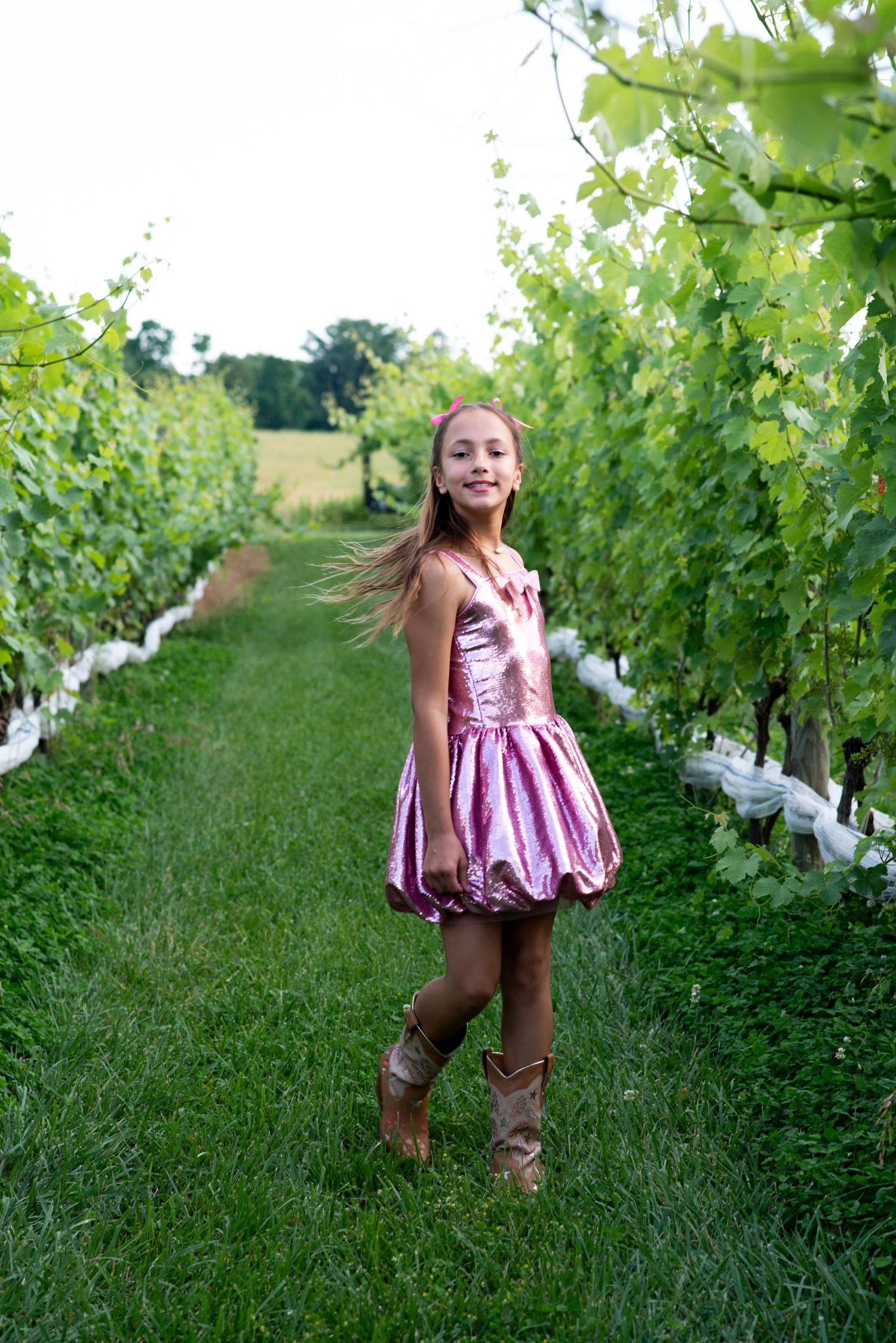 Girl in pink dress twirls for portrait in the vineyard at Stokelan Winery in Medford, New Jersey.