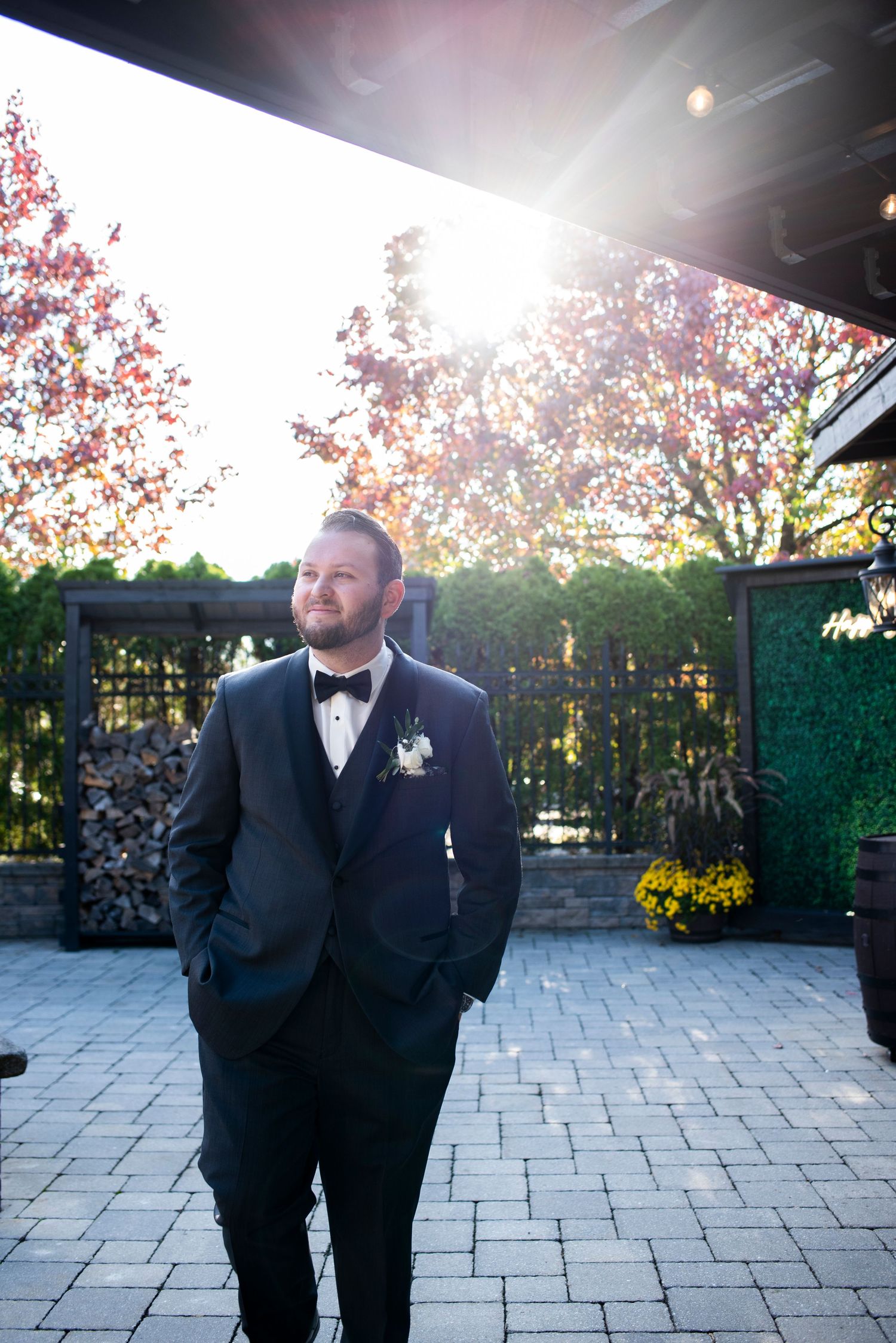 Groom poses for portrait with hands in pockets in the sunlight outside at Hamilton Manor, New Jersey.