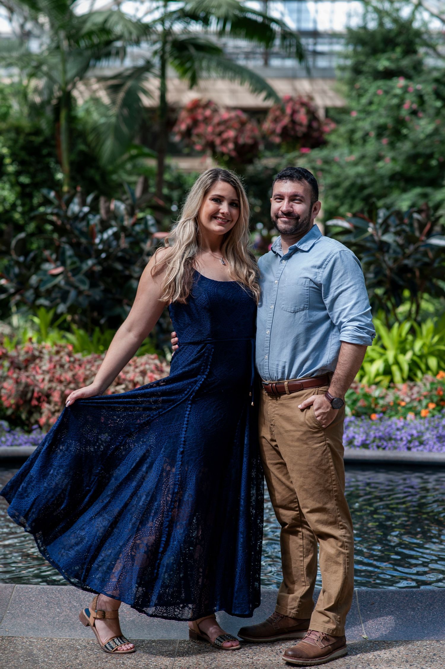 Engaged couple smiles for a portrait in the conservatory at Longwood Gardens in Pennsylvania.